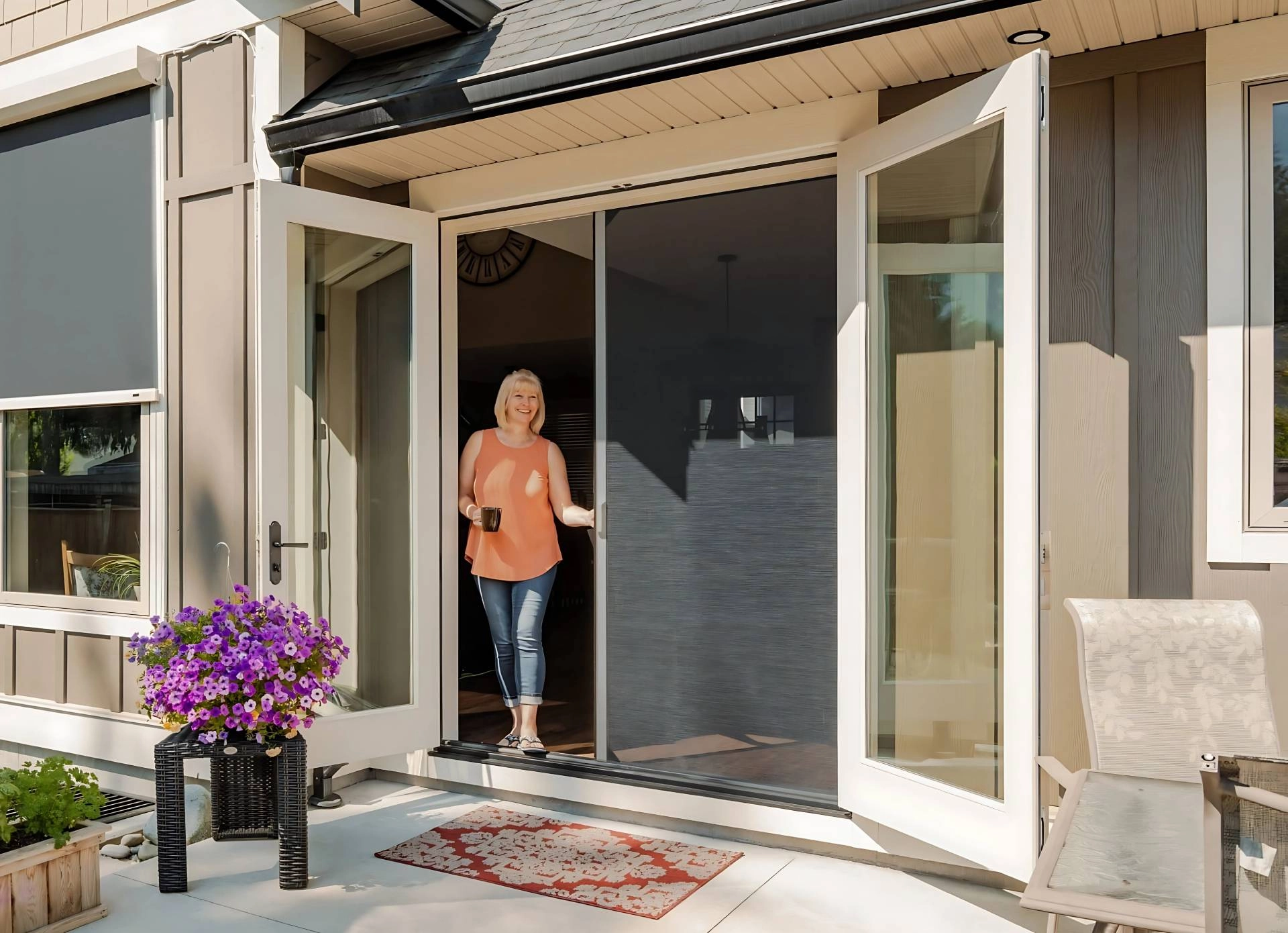 A woman standing in front of Phantom Motorized Patio Screens on French doors near Arvada, Colorado (CO)