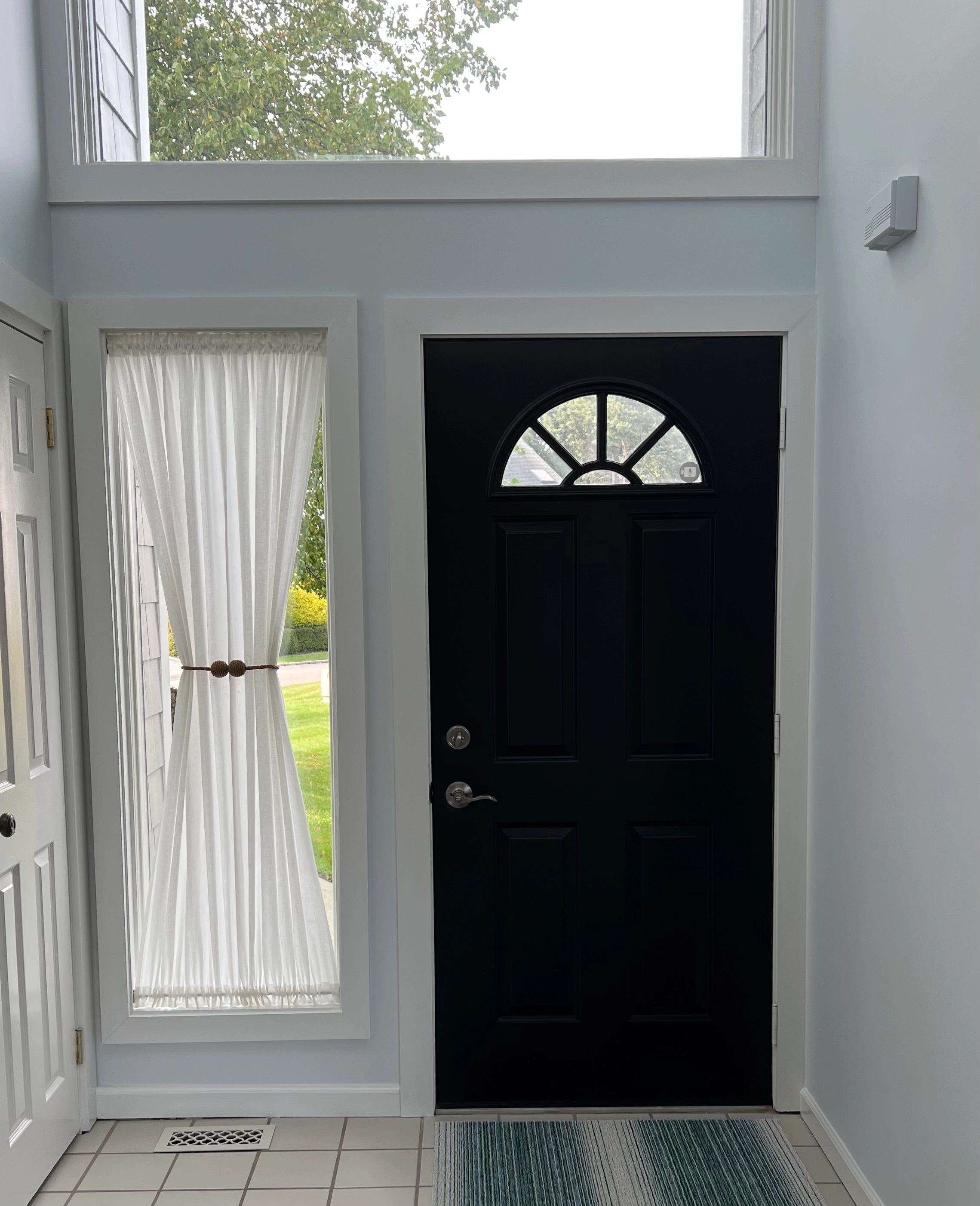 Drapery in a window next to a front door.