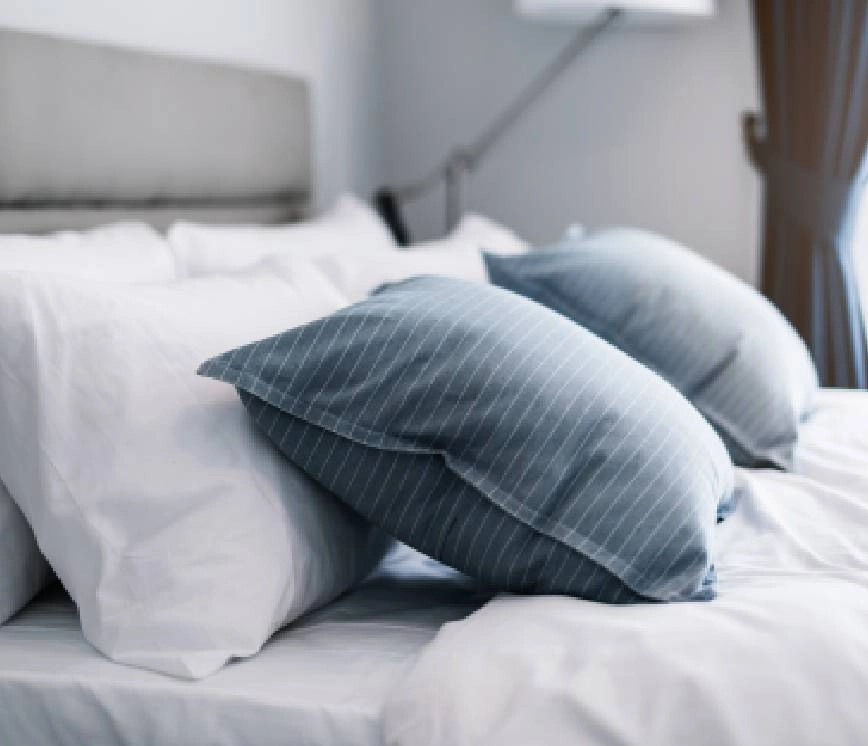 Custom bedding and pillows on a large bed.