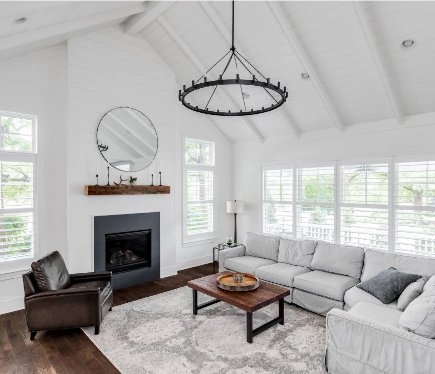 Modern farmhouse living room with sectional sofa, coffee table, and fireplace.