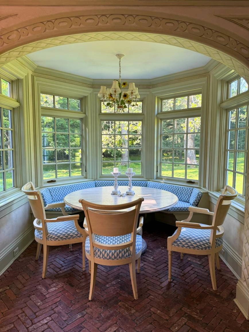 Reupholstered bench and dining chairs in a sunlit Long Island dining nook