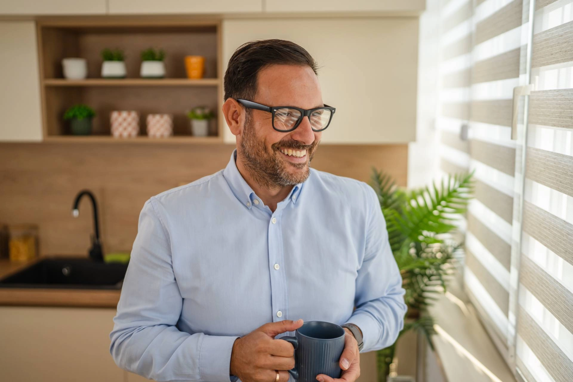 Man enjoying his morning coffee in a quiet home thanks to his sound-deadening window treatments
