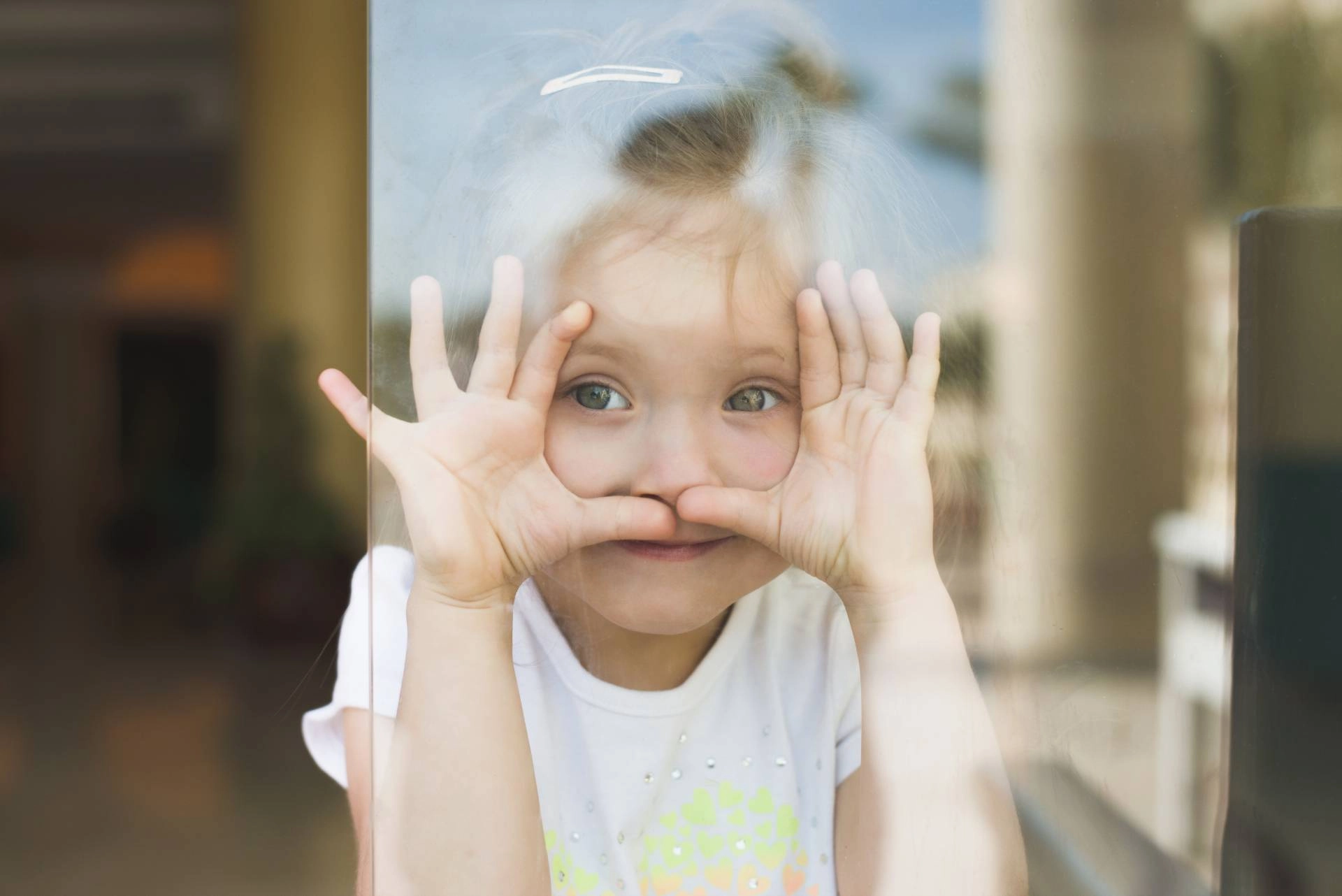 A young child looks through a window from their home near Denver, Colorado (CO)