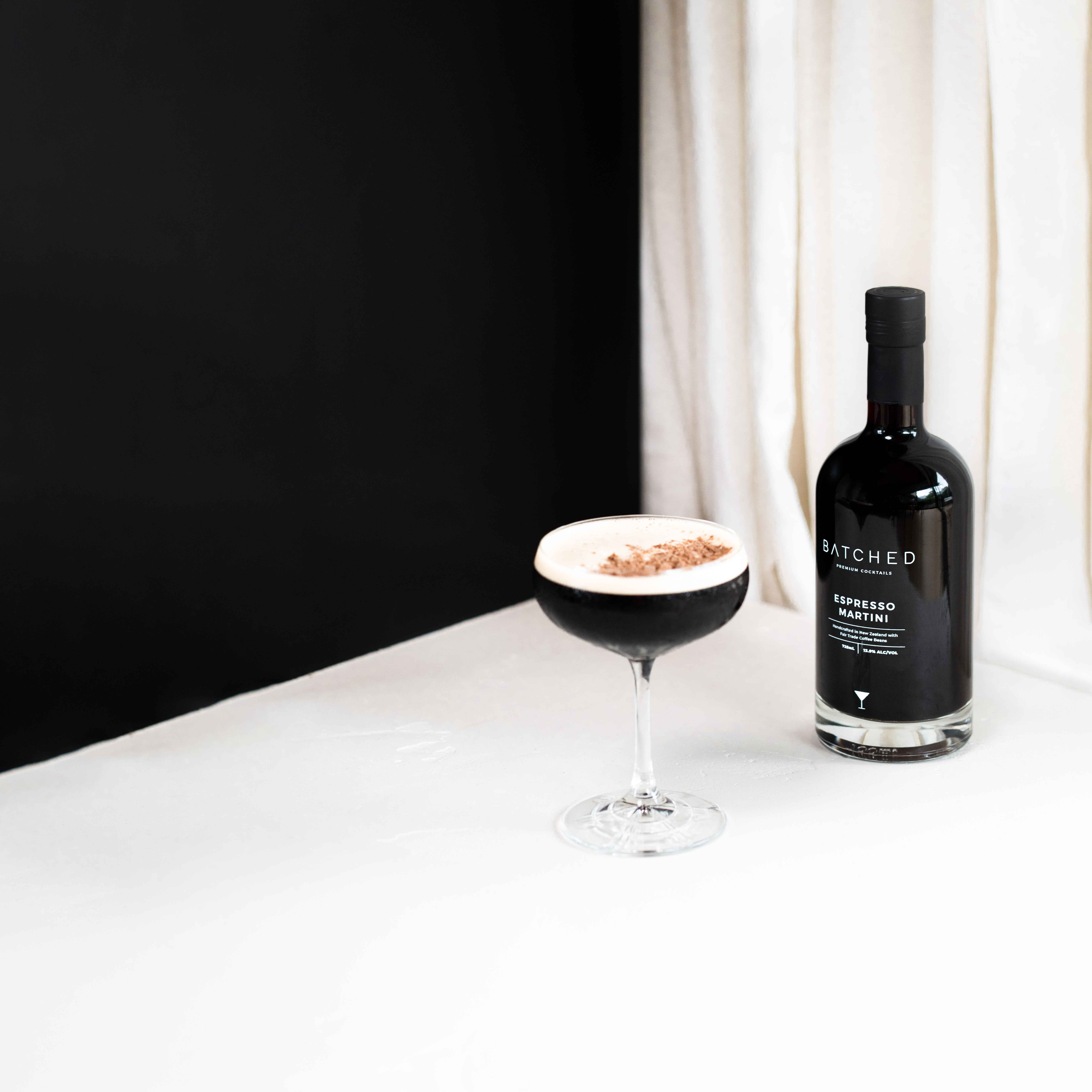 Batched Espresso Martini bottle and glass served on table with black and white background