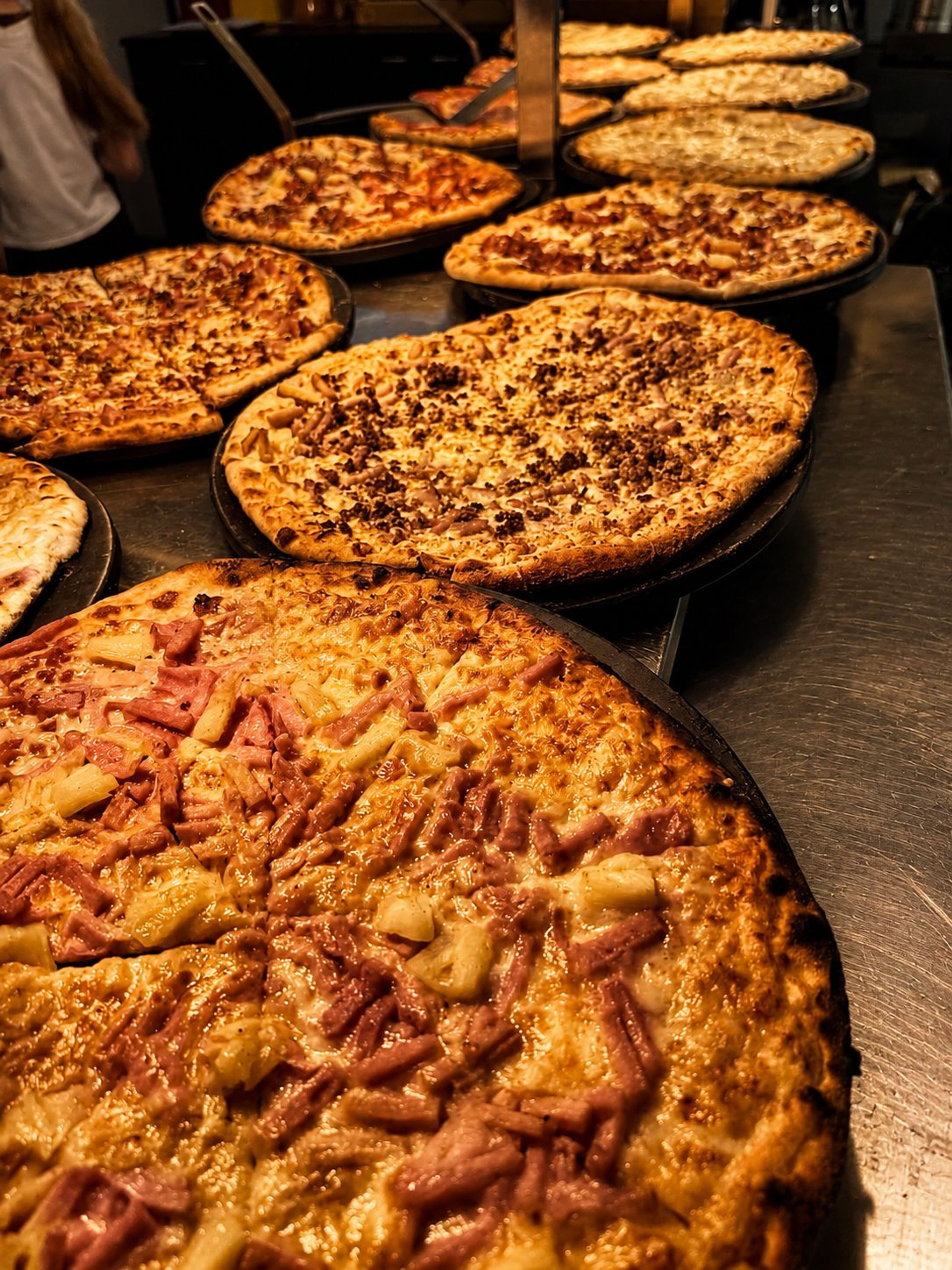 Buffet pizzas on their pans