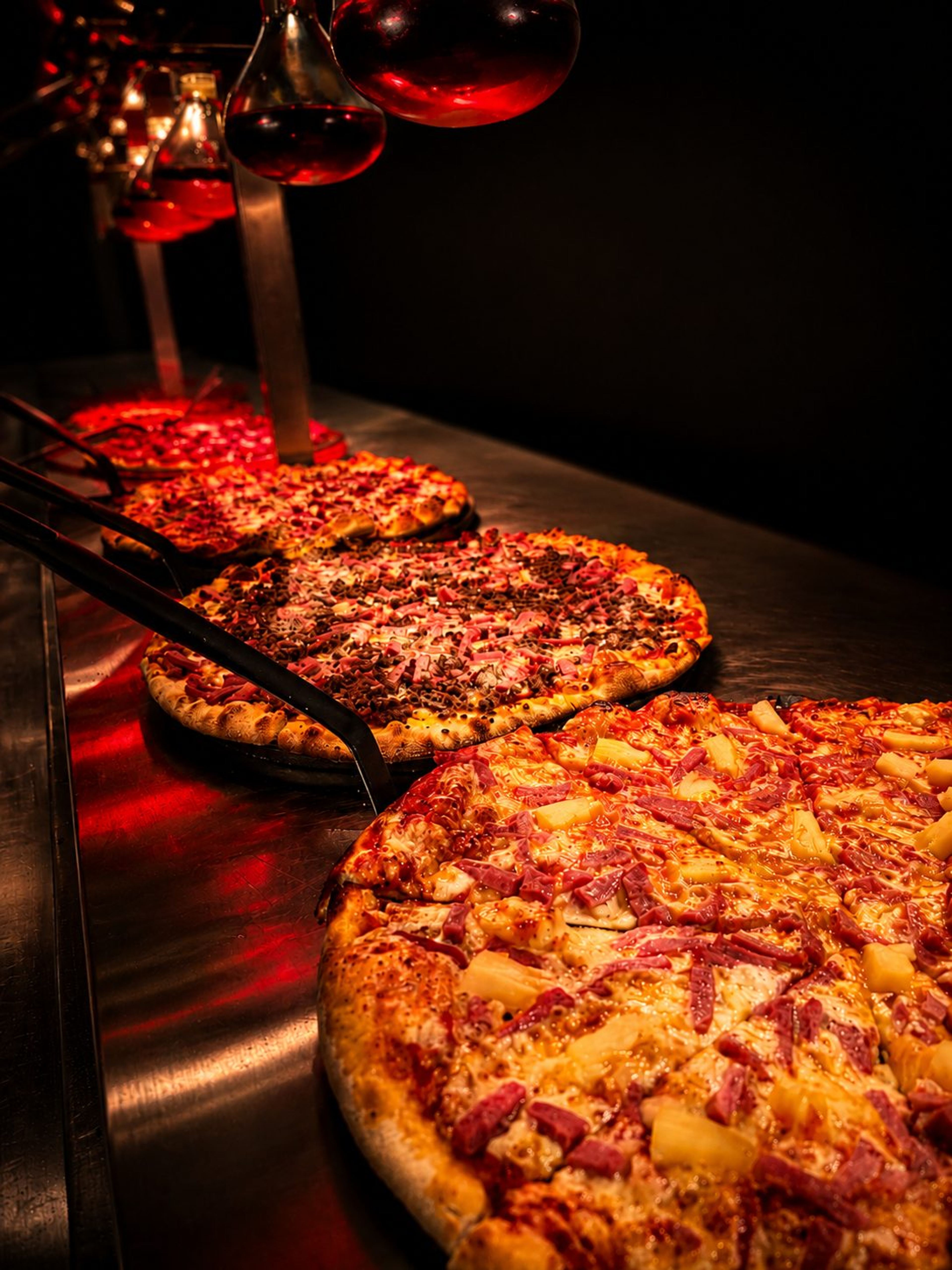 A pizza under the heat lamps on the buffet line