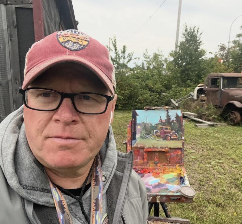 artist outdoors beside easel painting vintage truck scene
