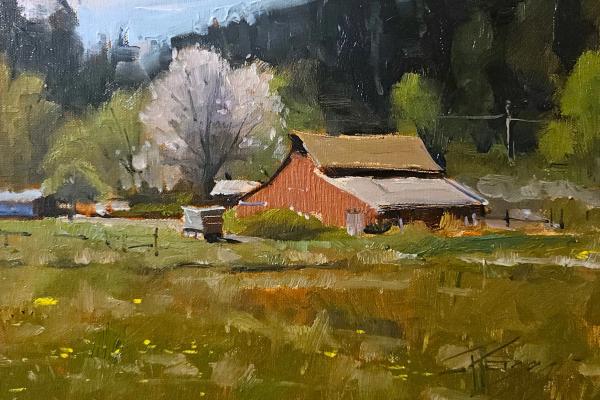 plein air painting of red barn in a spring meadow with blooming trees