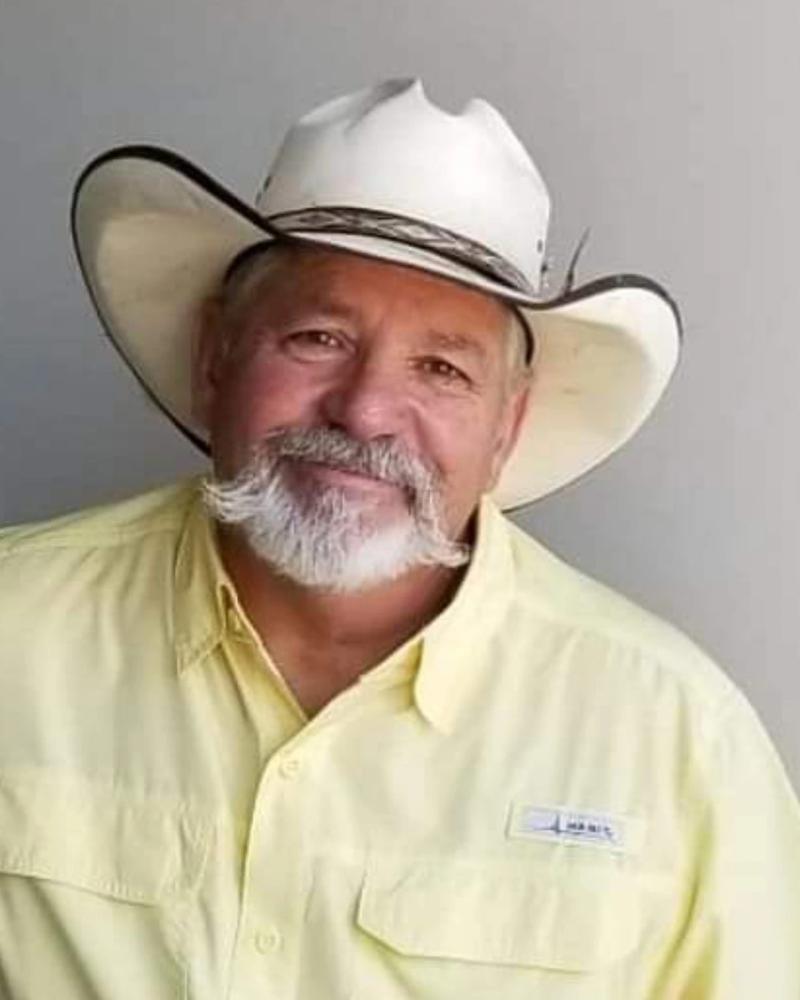 portrait of a man with a white beard wearing a cowboy hat and a yellow button-down shirt