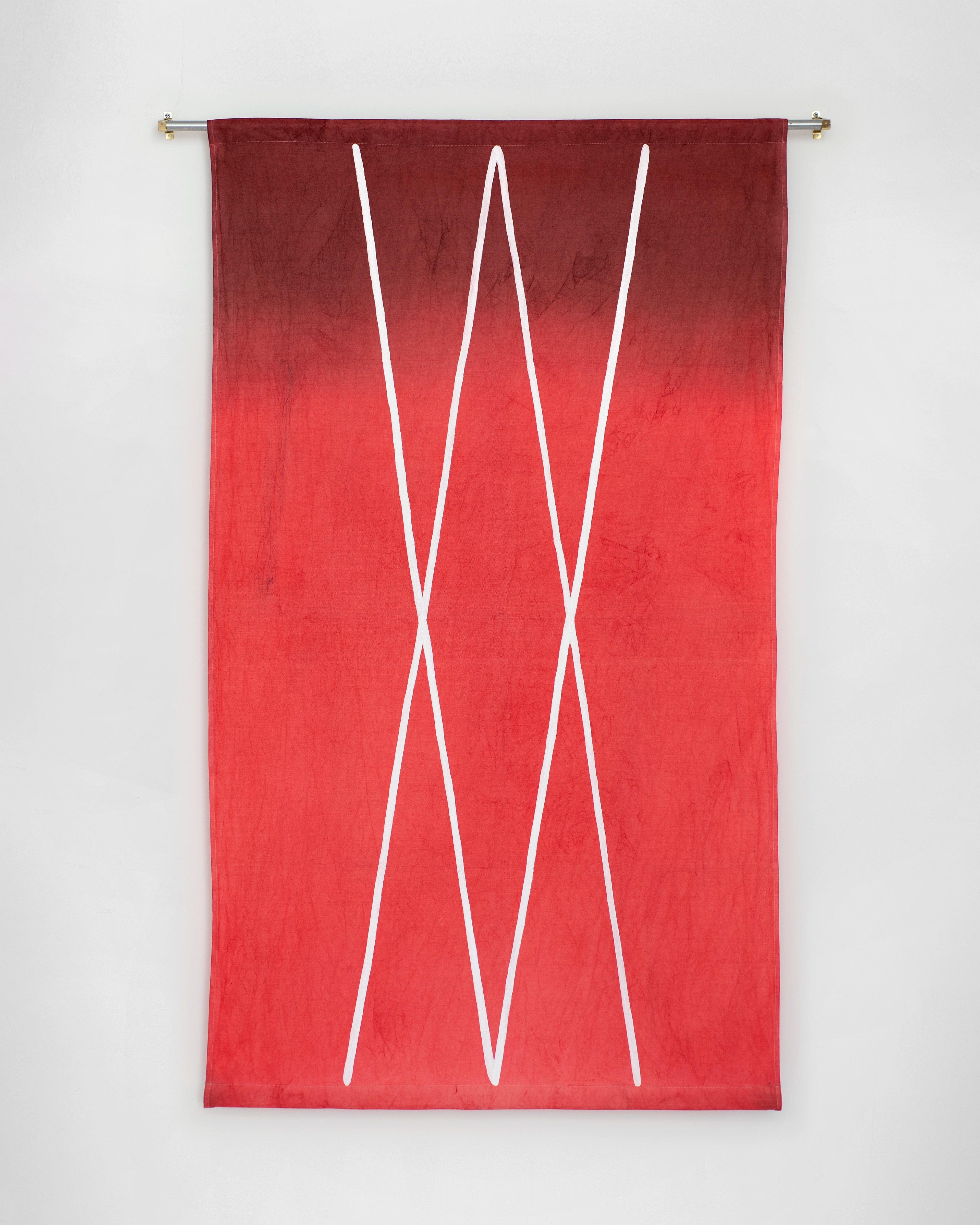Vertical hand-dyed cotton banner in ombre red transitioning from burgundy to bright scarlet, with three white diagonal lines forming angular zigzag pattern s…
