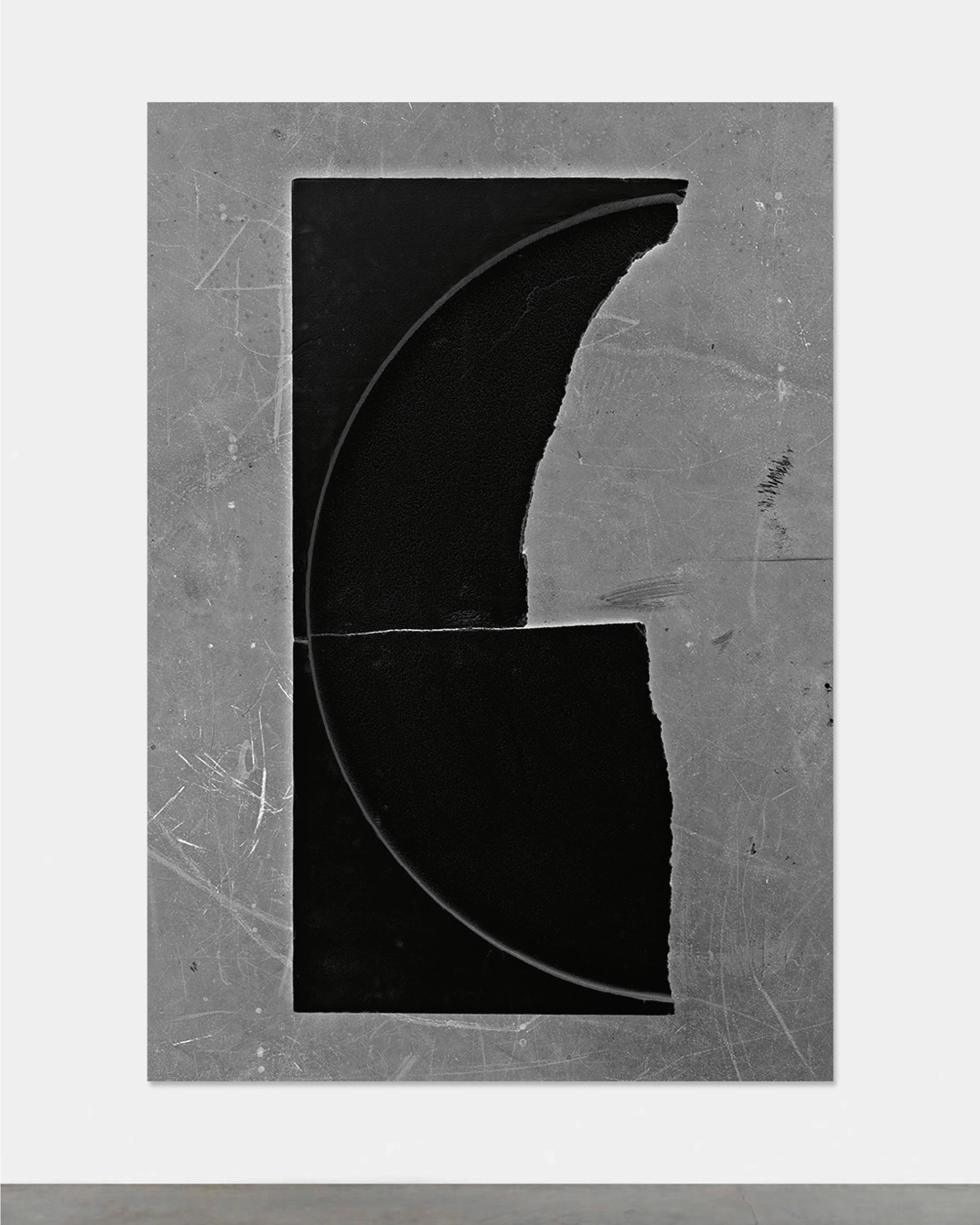 Monochromatic abstract composition with black curved geometric forms dividing a weathered grey rectangular surface, creating negative space and suggesting fr…