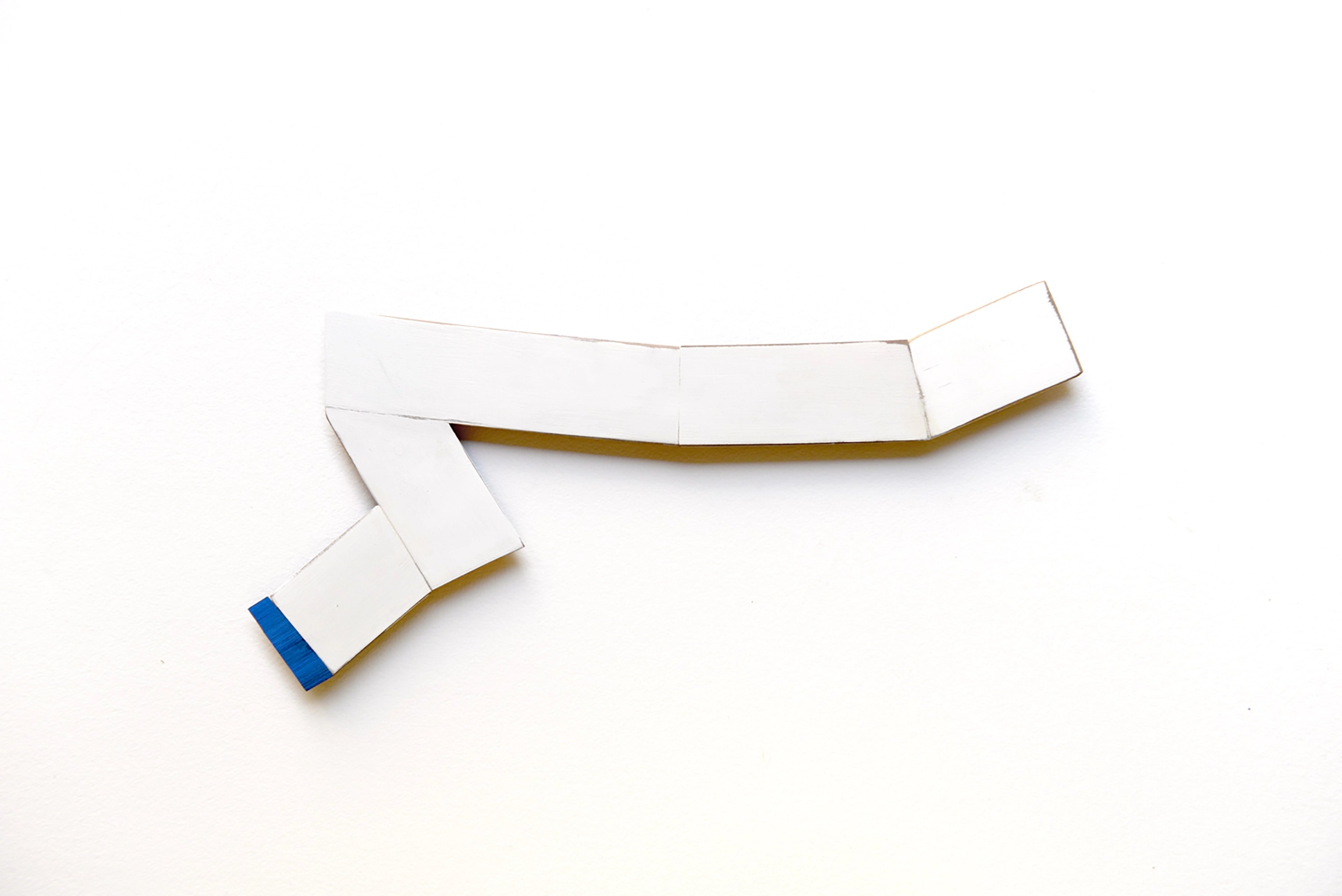 Curved white wooden strips with blue paint accent arranged in dynamic composition against white background