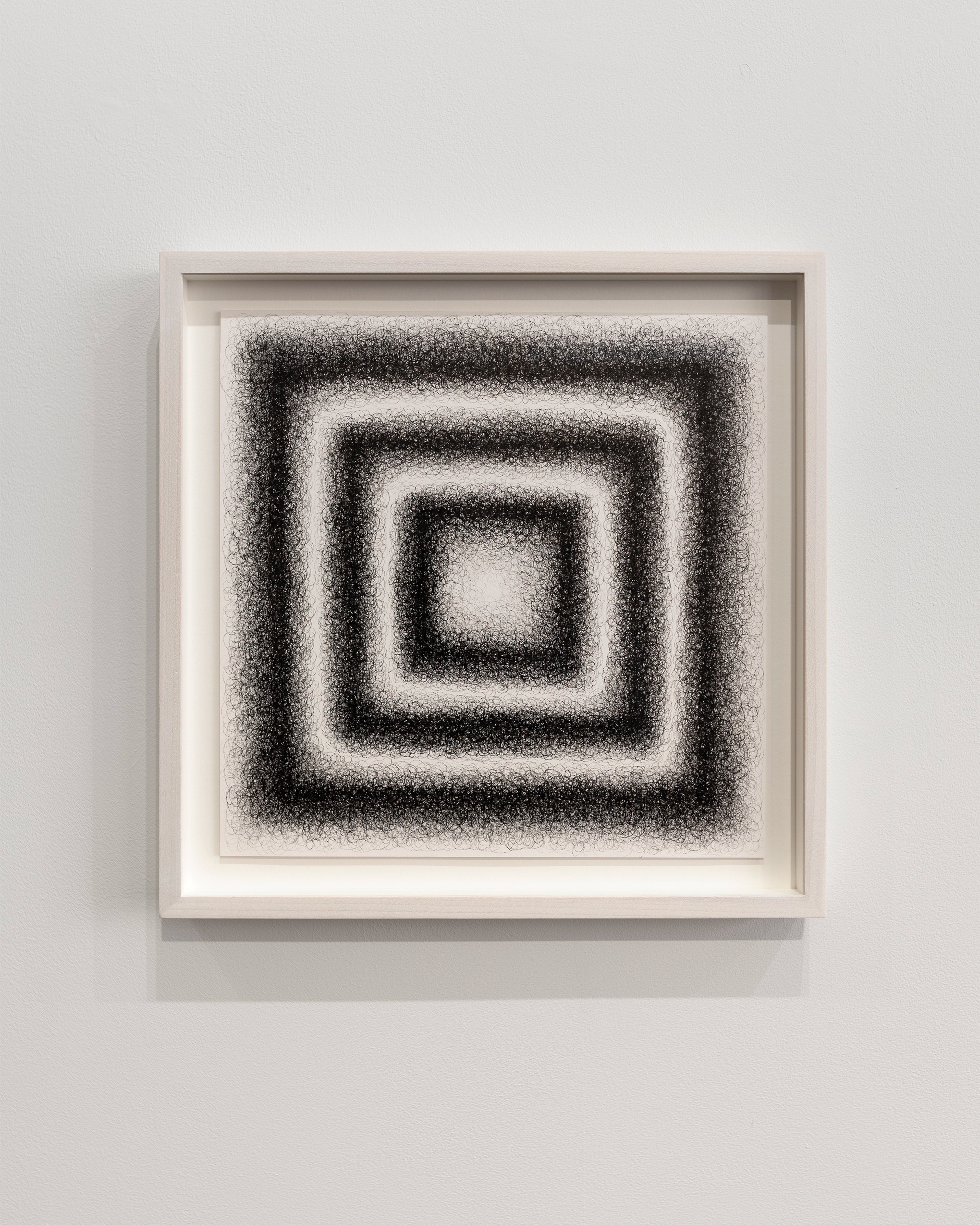 Framed drawing of four concentric squares rendered in black stippled pigment against white paper, creating a textured optical effect through granular marks.