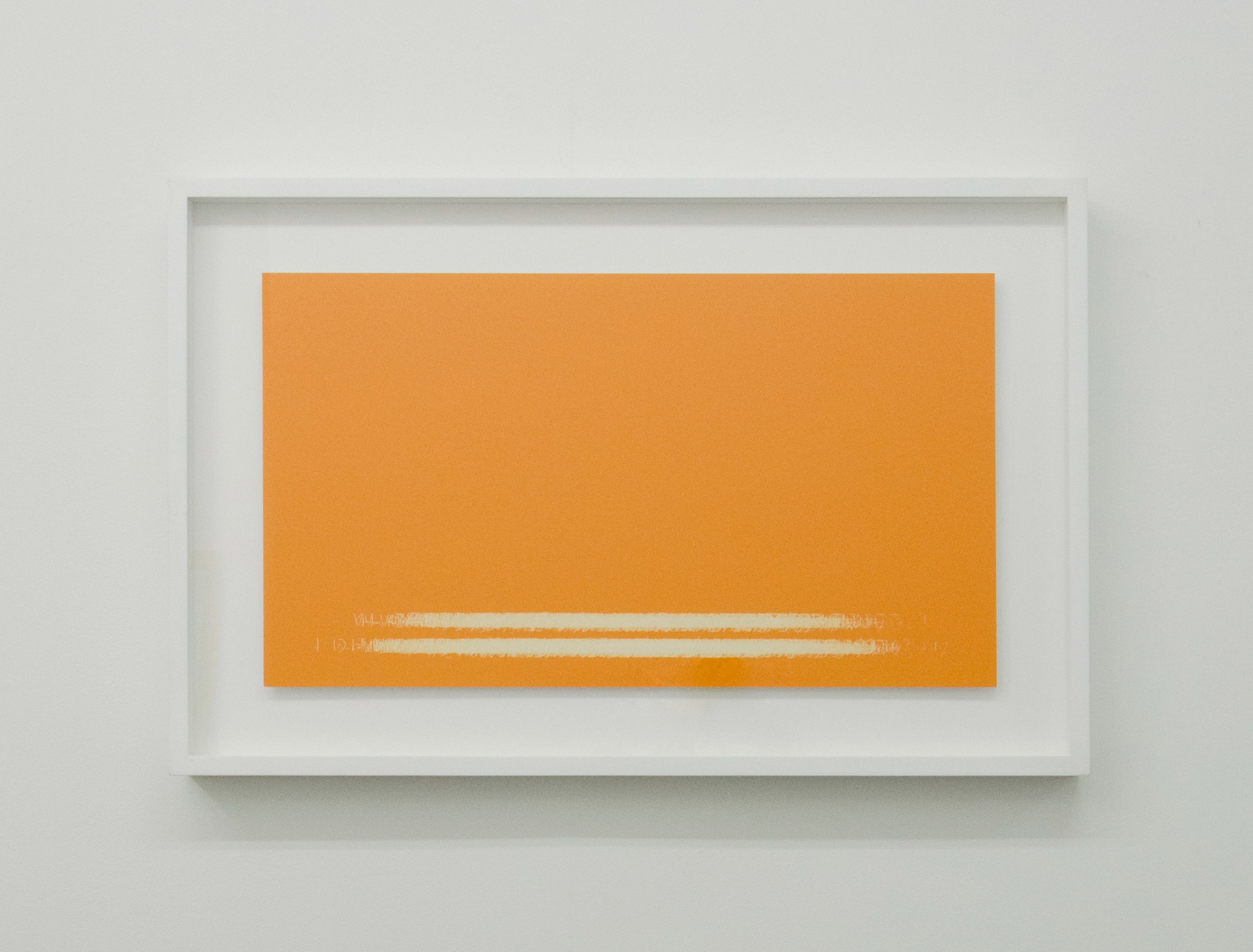 Bright orange rectangular panel with two horizontal white text lines near its center, mounted in white frame against gallery wall