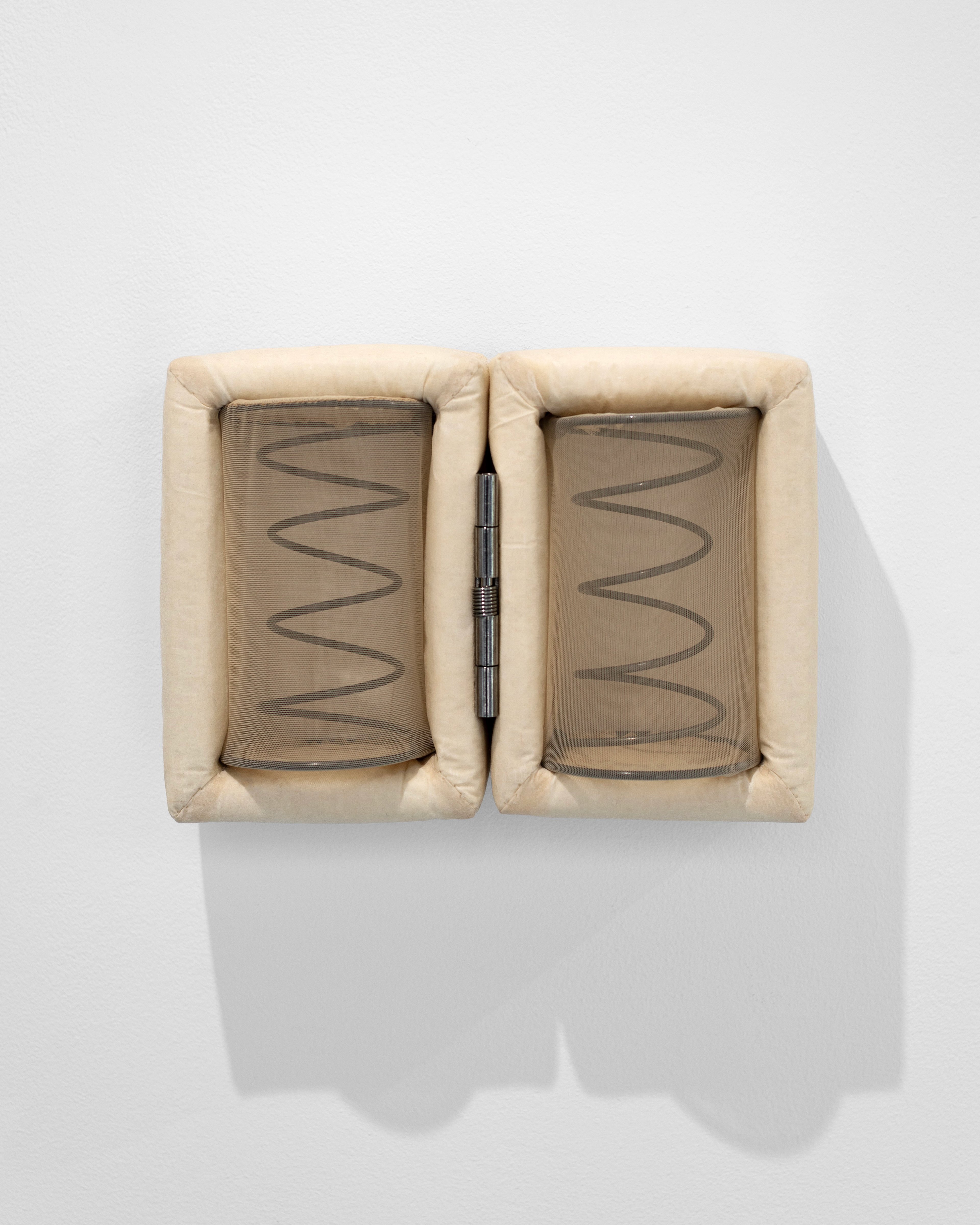 Two cream-colored quilted fabric frames with exposed metal springs and wavy lines, separated by a black pen placed vertically between them against a white wall
