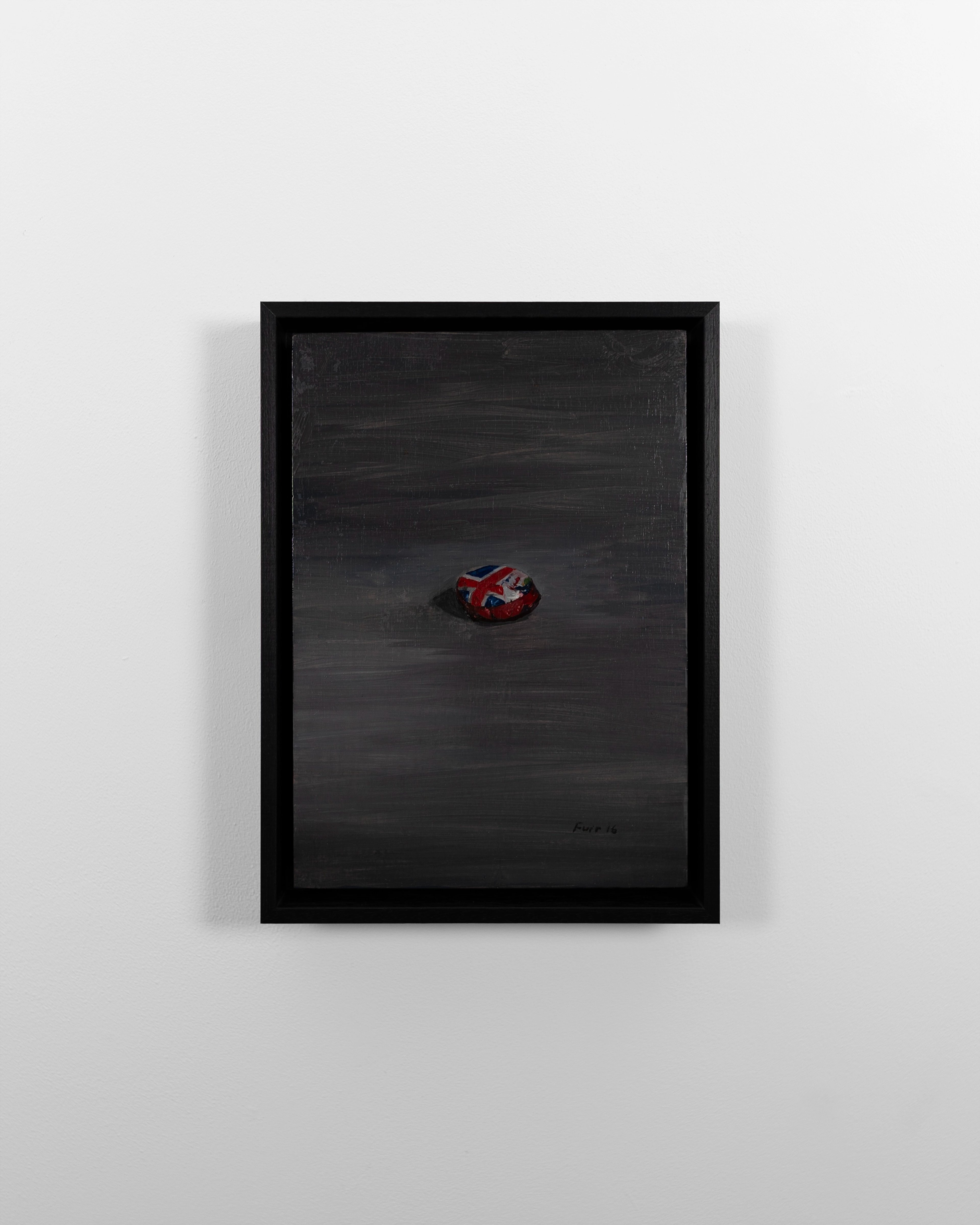 Oil painting on gessoed panel in black frame depicts a small red object with Union Jack detail centered on dark grey background.