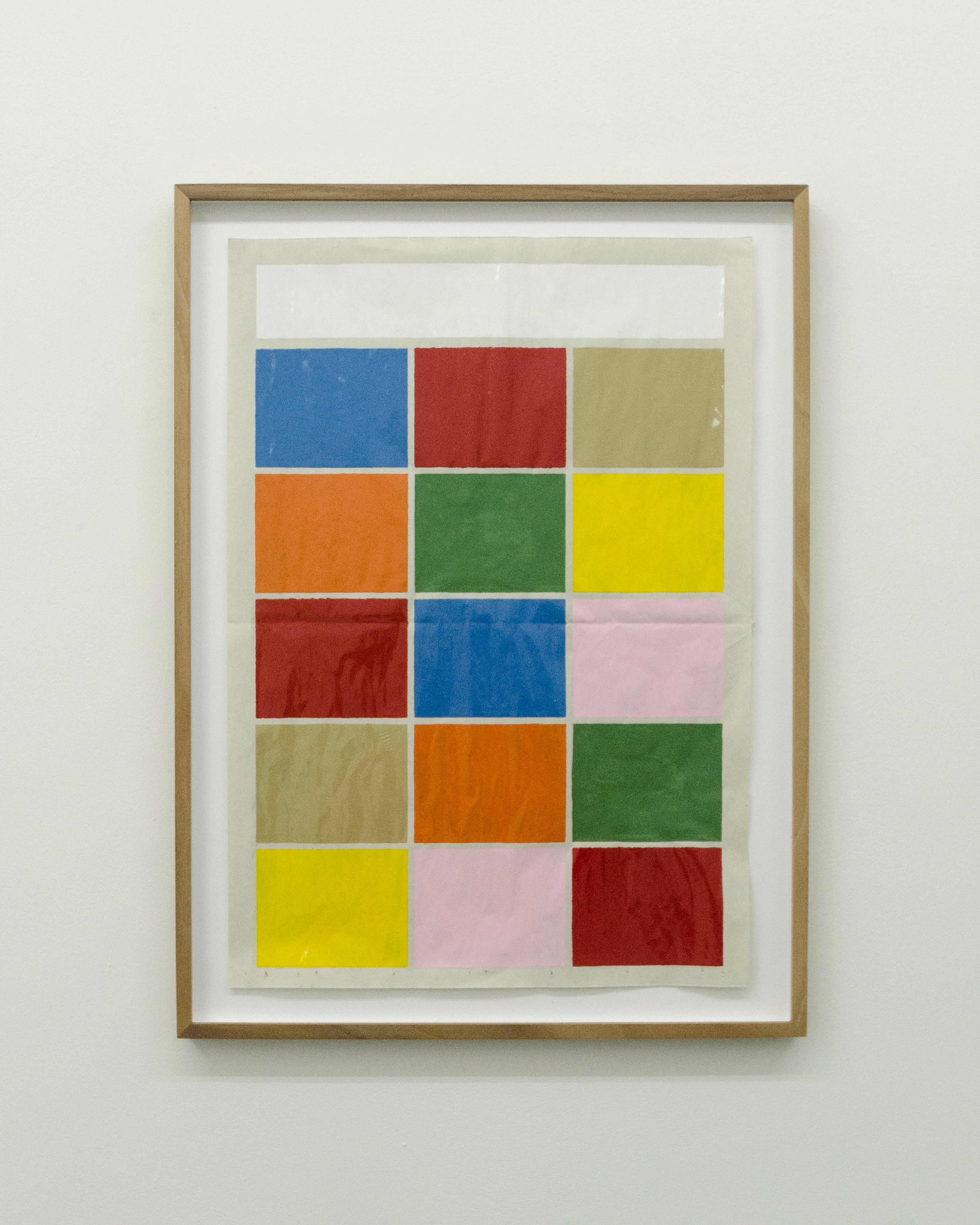 Grid of colored rectangles—blue, red, ochre, orange, green, yellow, pink, and dark red—painted in lacquer on newspaper, framed in natural wood