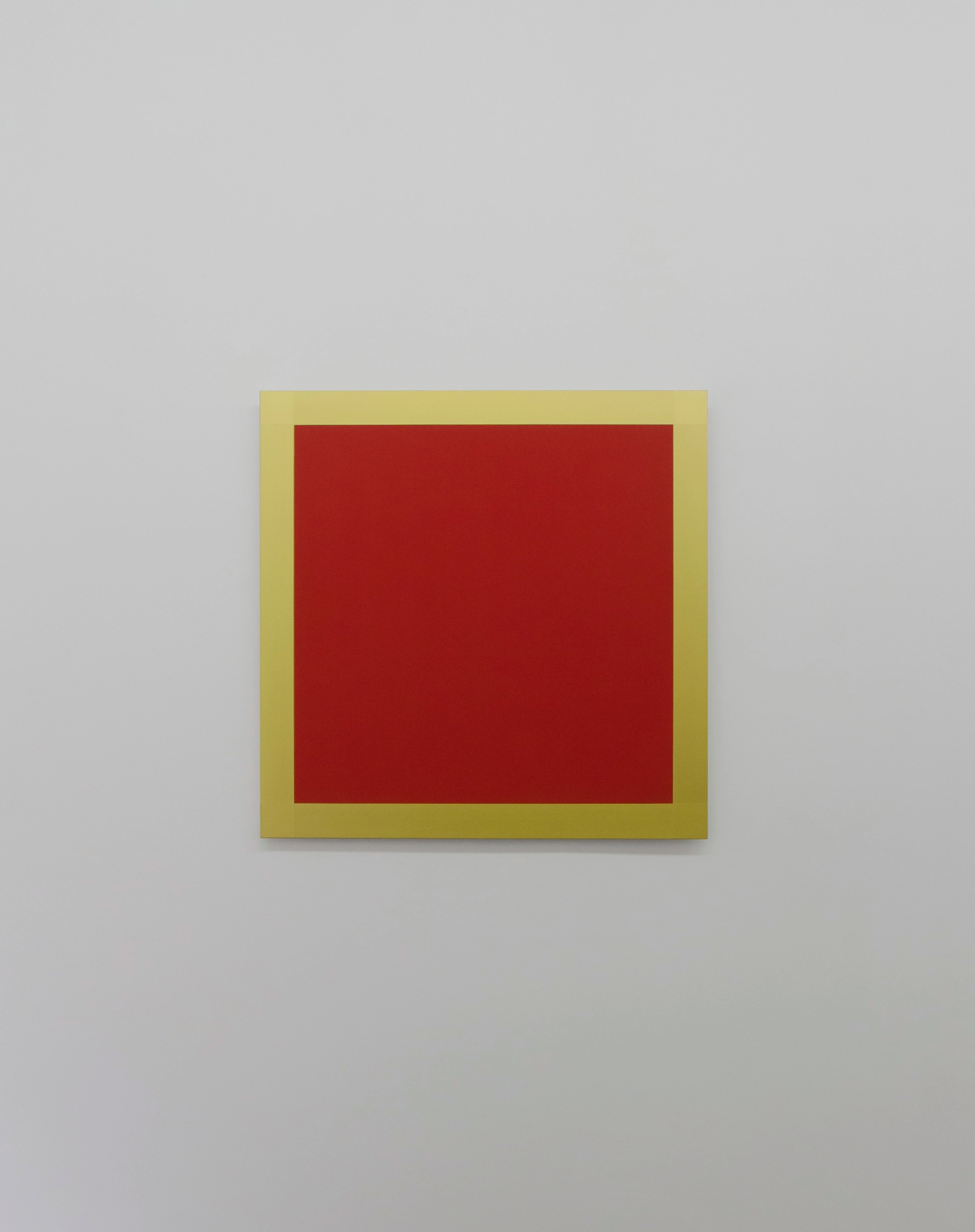 Concentric square composition with deep red centre framed by mustard-yellow border on dibond panel against neutral wall