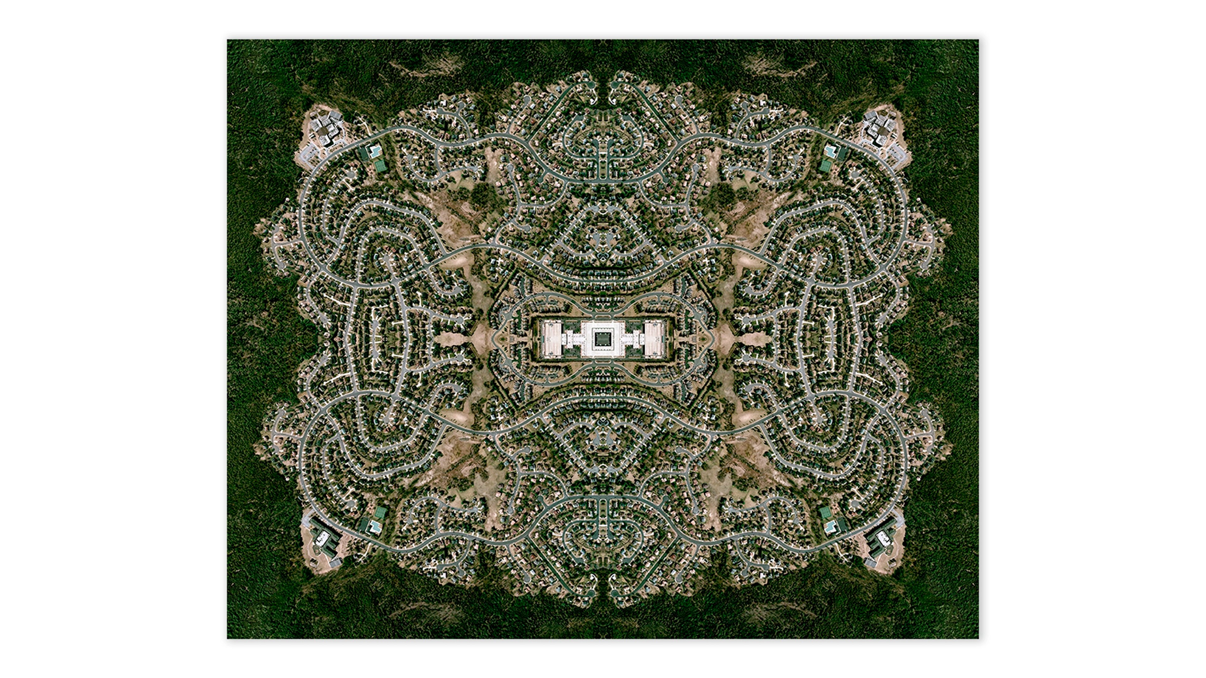 Aerial photograph of suburban sprawl symmetrically mirrored to create a mandala-like pattern, with a white modernist house at centre surrounded by dense resi…