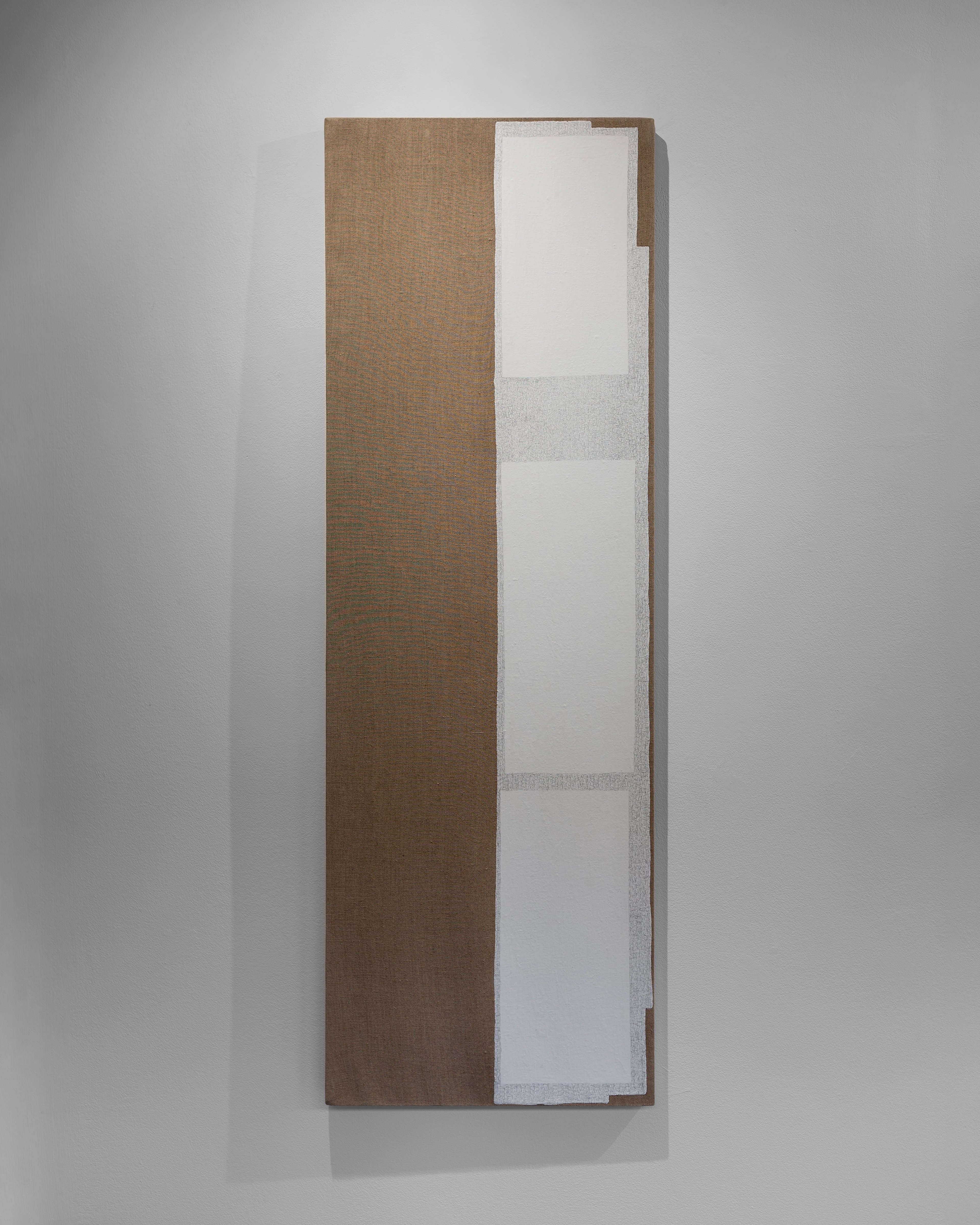 Tall rectangular linen panel divided vertically, left side covered in dark charcoal and beeswax, right side featuring stacked white and grey acrylic rectangl…