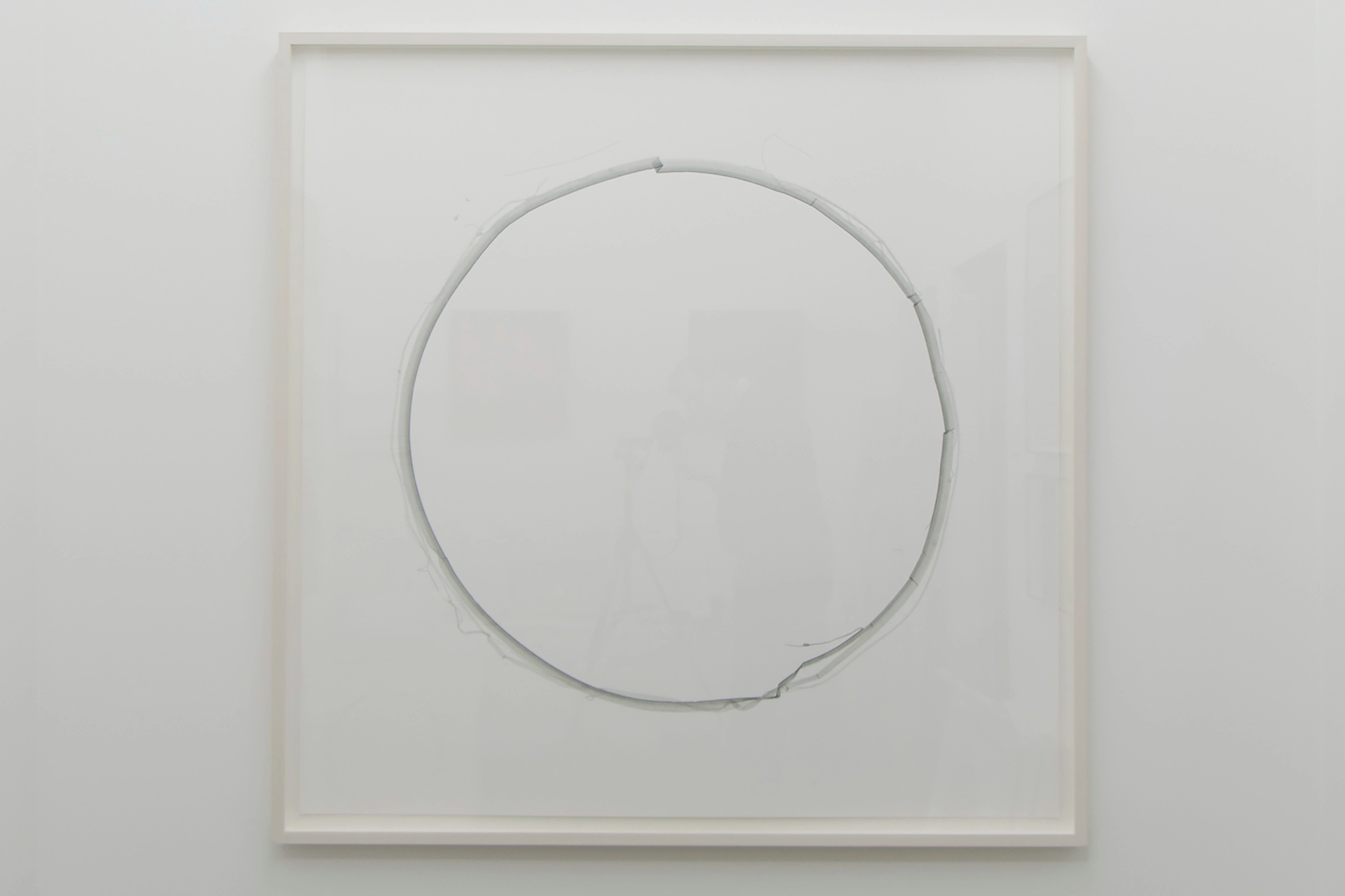 Fine gray circle drawn in ink on cream paper, mounted within a white frame