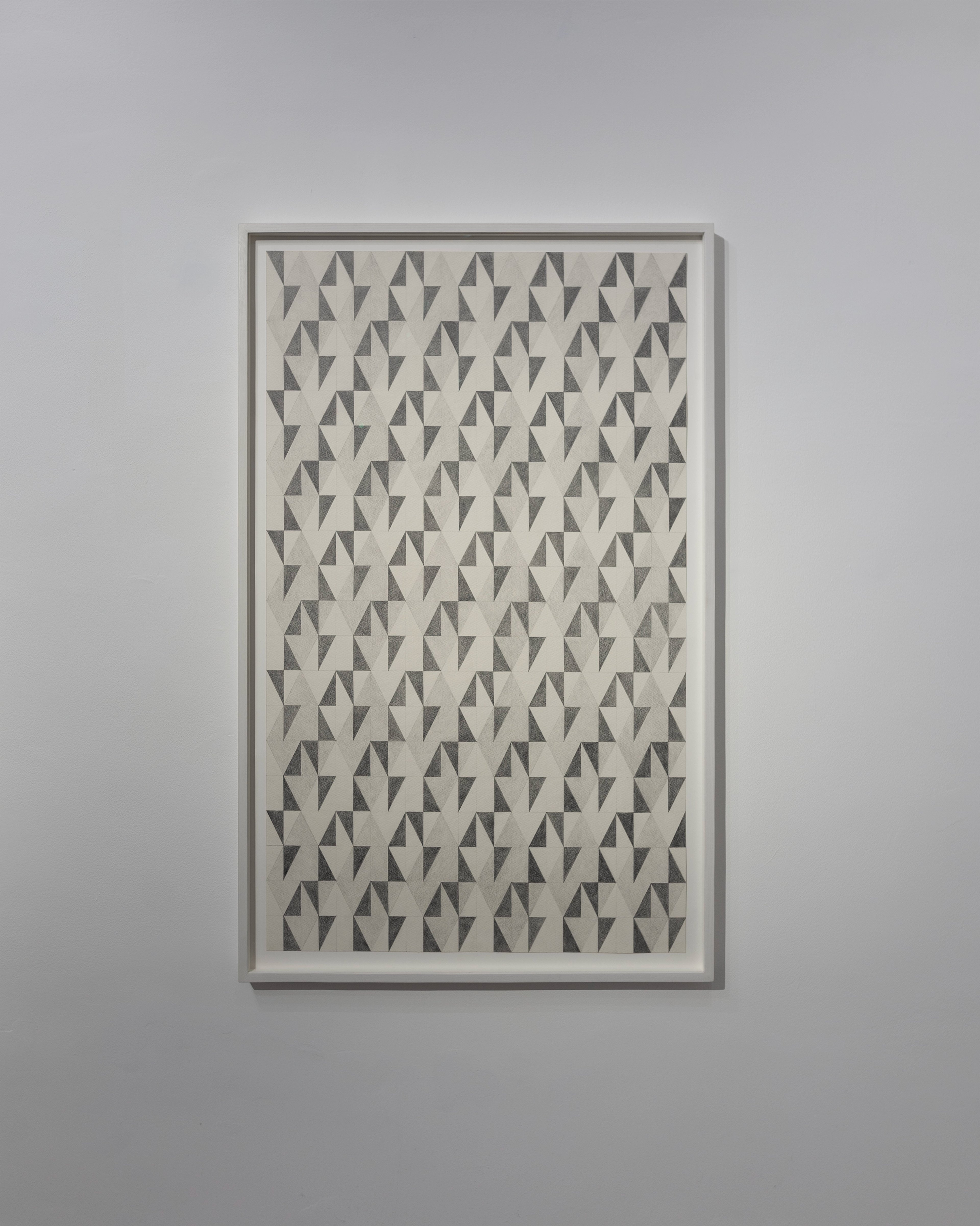 Framed graphite drawing of repeating geometric pattern composed of interlocking triangular forms in grey and cream tones