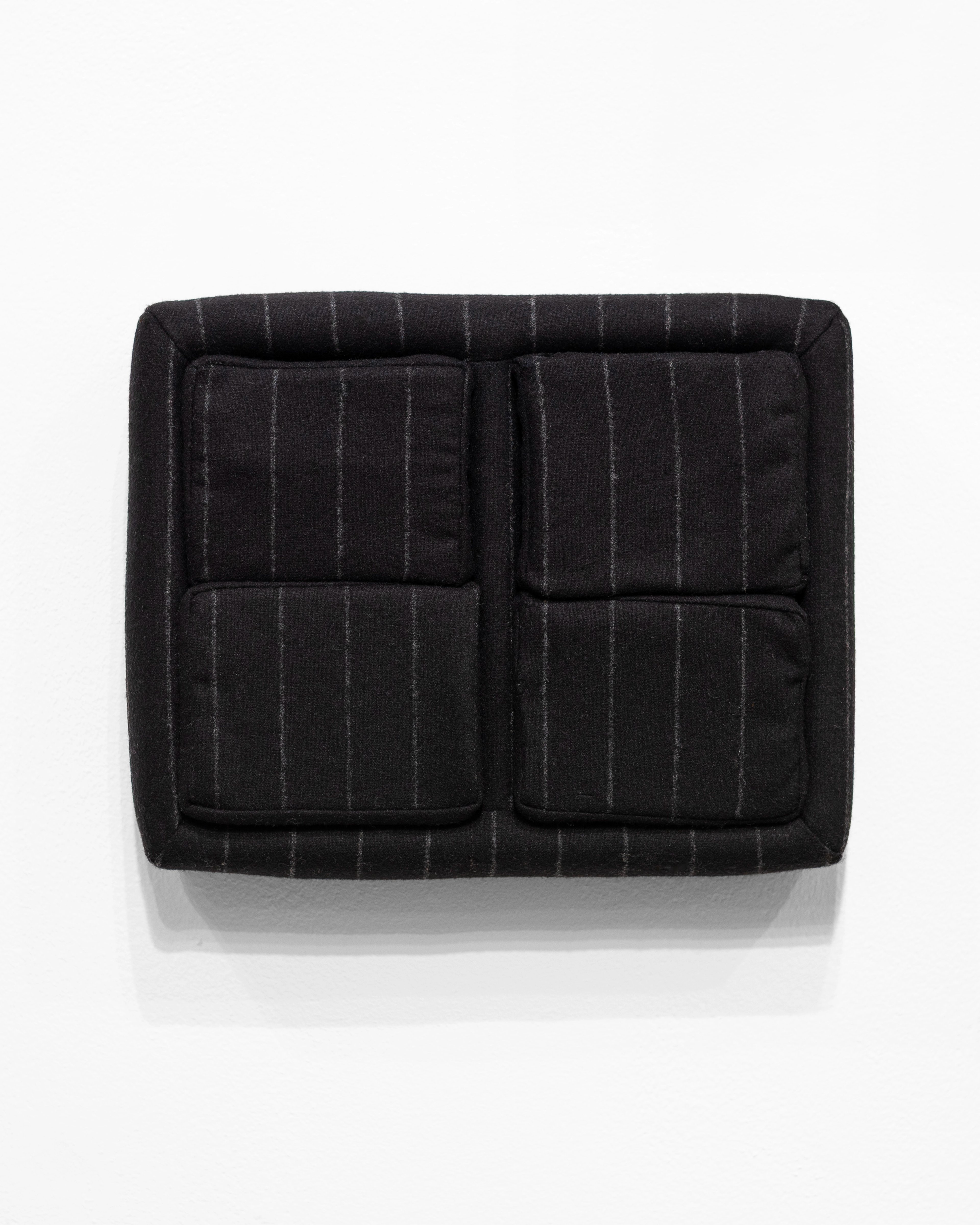 Black pinstriped wool upholstered case with four quilted cushion sections arranged in a grid, mounted on white wall