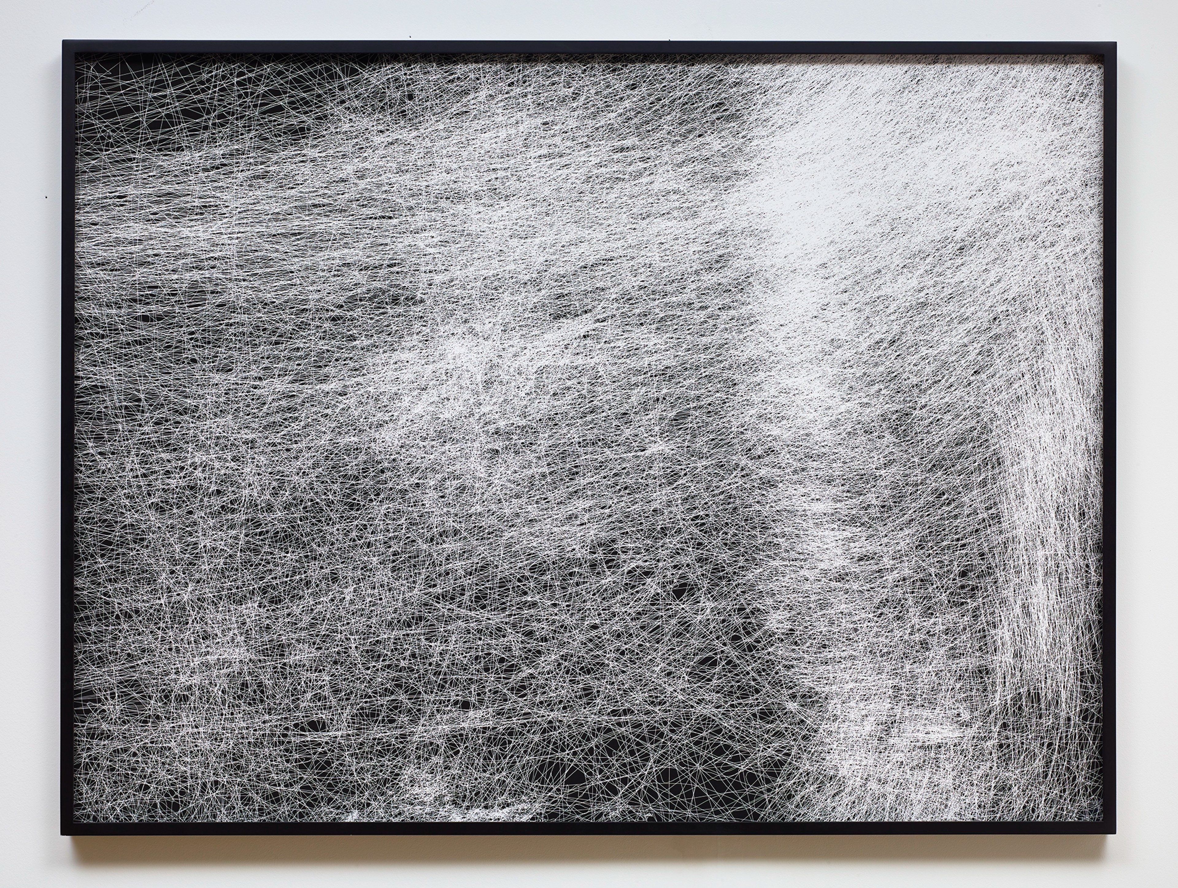 Dense network of fine white lines creating gestural, flowing patterns across black paper, suggesting captured movement and energy through layered linear marks.