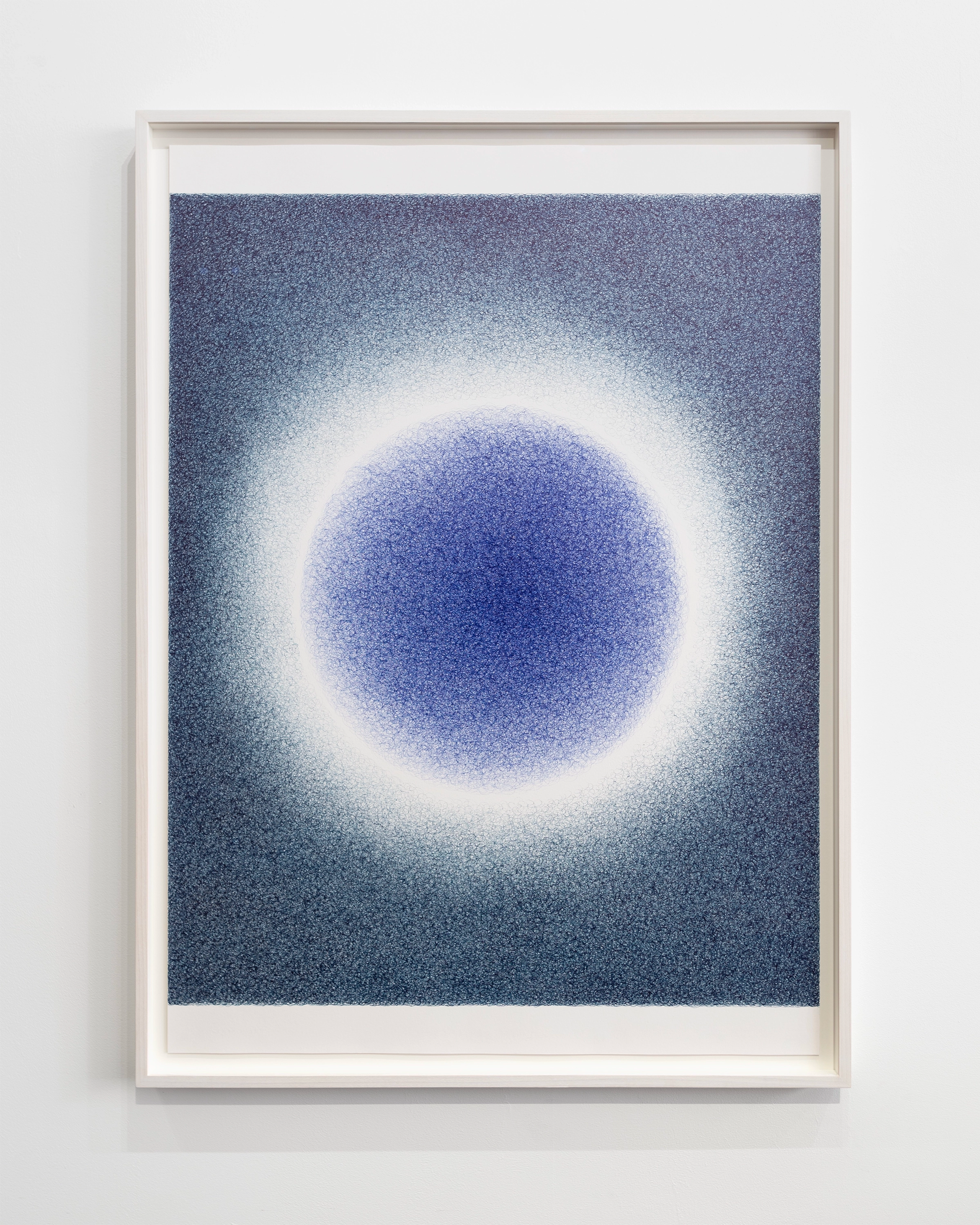 Concentric circles of deep blue and white radiating from a glowing center, created with pigmented ink on paper in a white frame