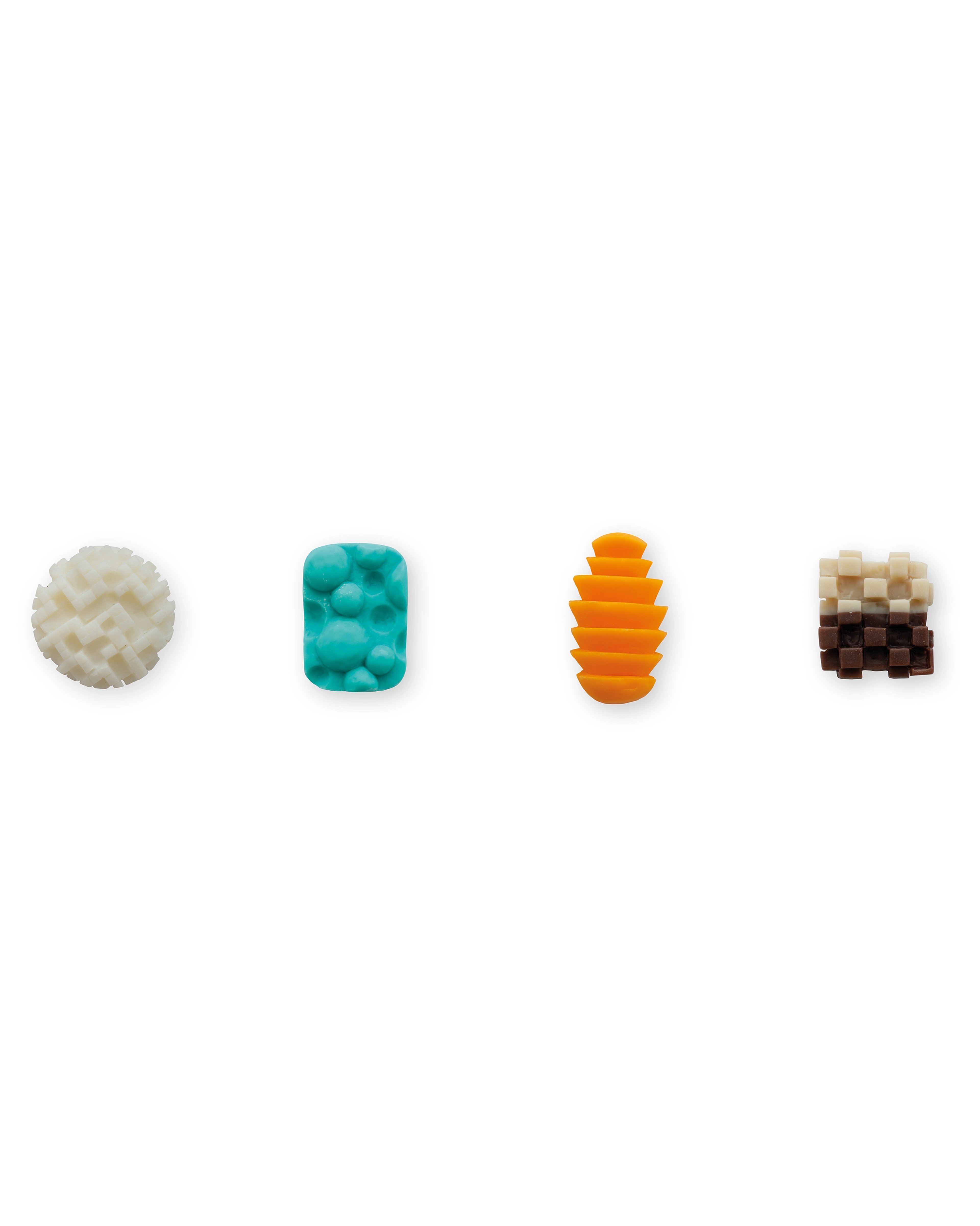 Four carved soap sculptures in a row: cream interlocking pattern sphere, turquoise bubble-textured rectangle, orange stacked disc form, and pixelated gradien…