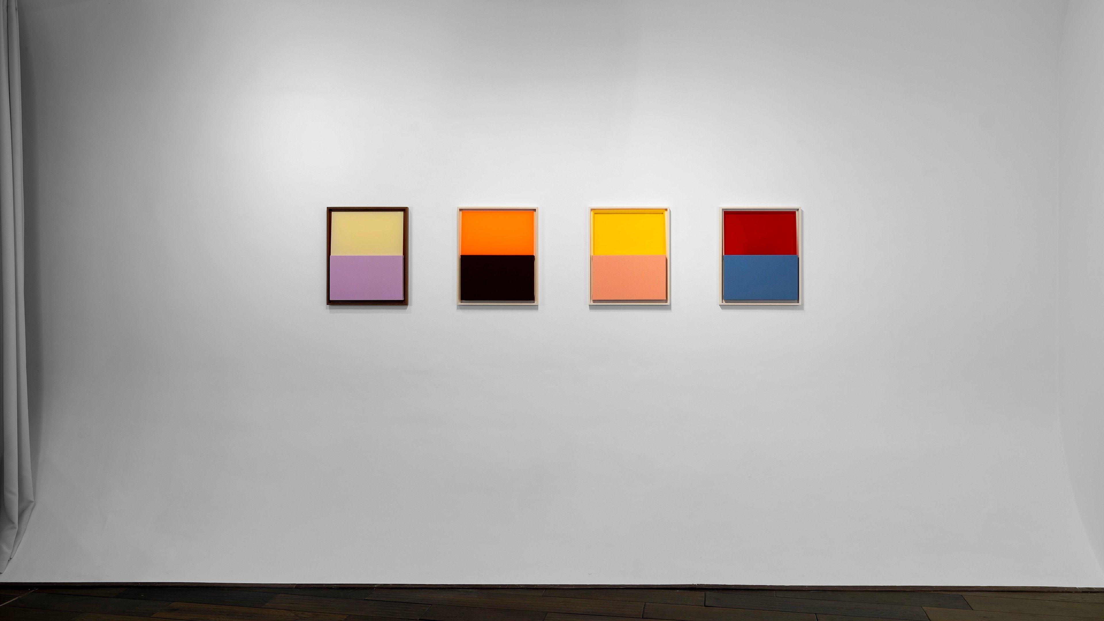 Four small square paintings with dark frames arranged horizontally, each divided into two horizontal colour bands: pale yellow-purple, orange-black, yellow-p…