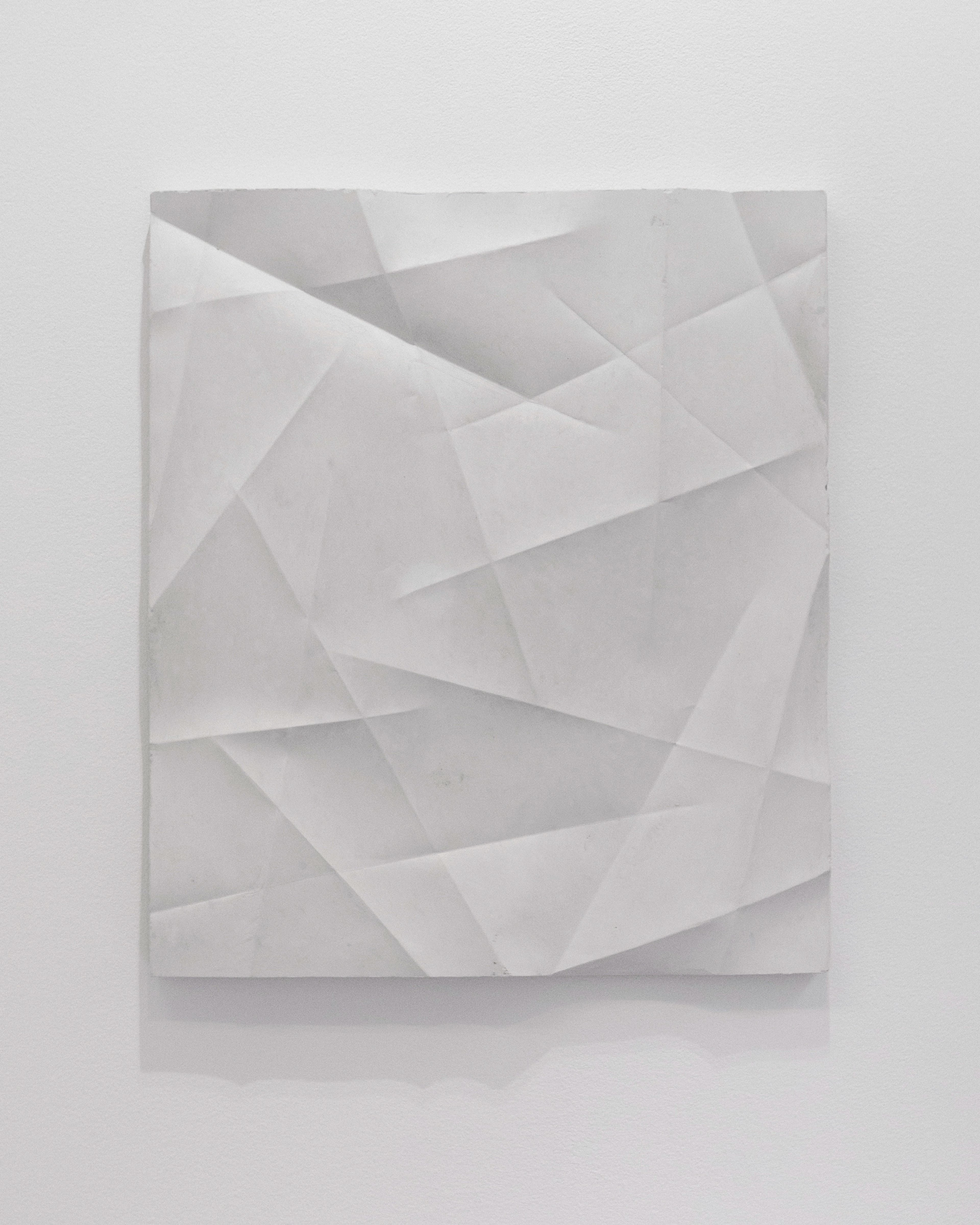 White plaster relief with overlapping geometric folds and planes creating dynamic shadows and depth across the squared composition