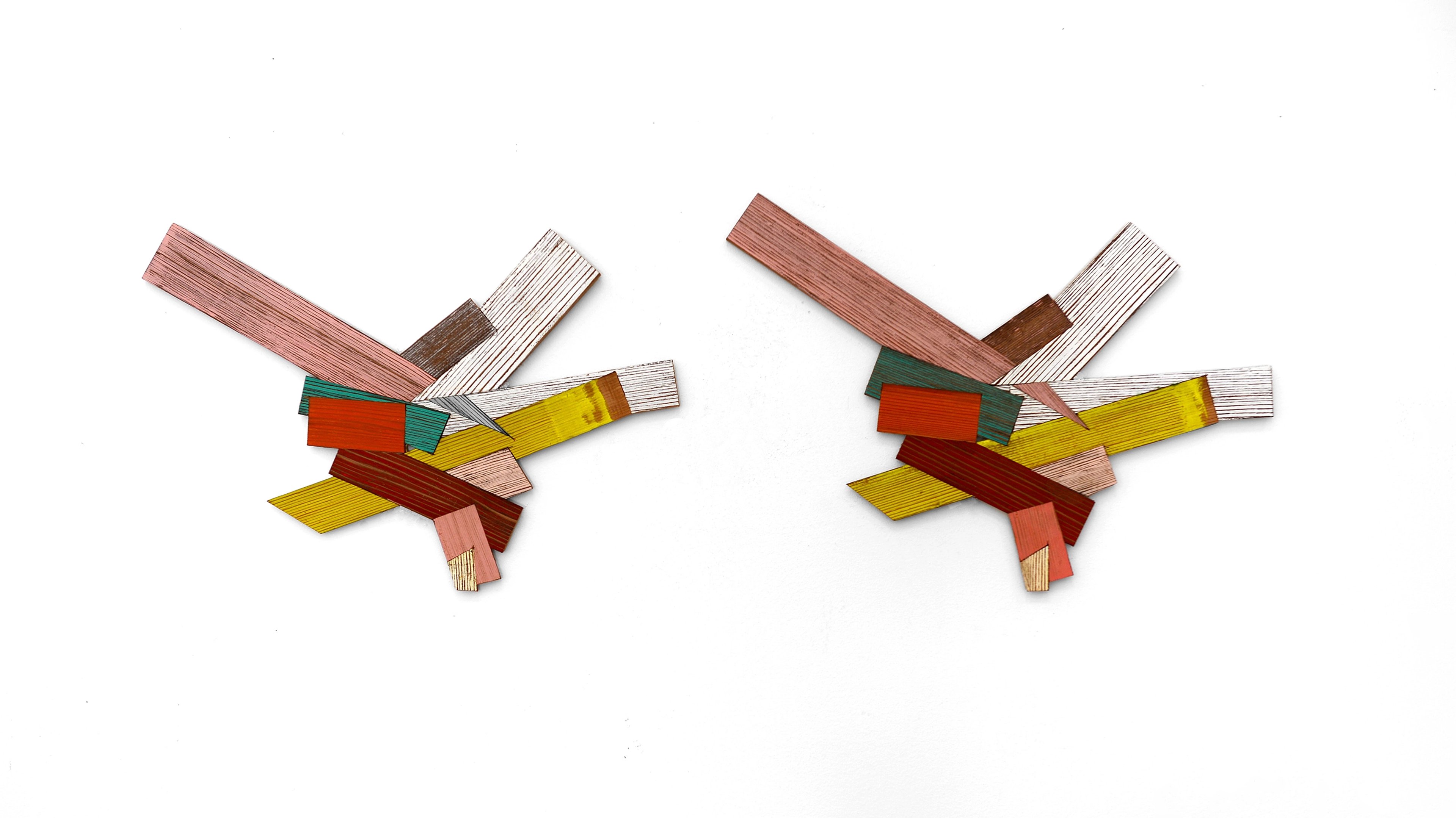 Two nearly identical abstract compositions of painted wooden strips in red, yellow, green, and natural wood tones, arranged in dynamic angular configurations…