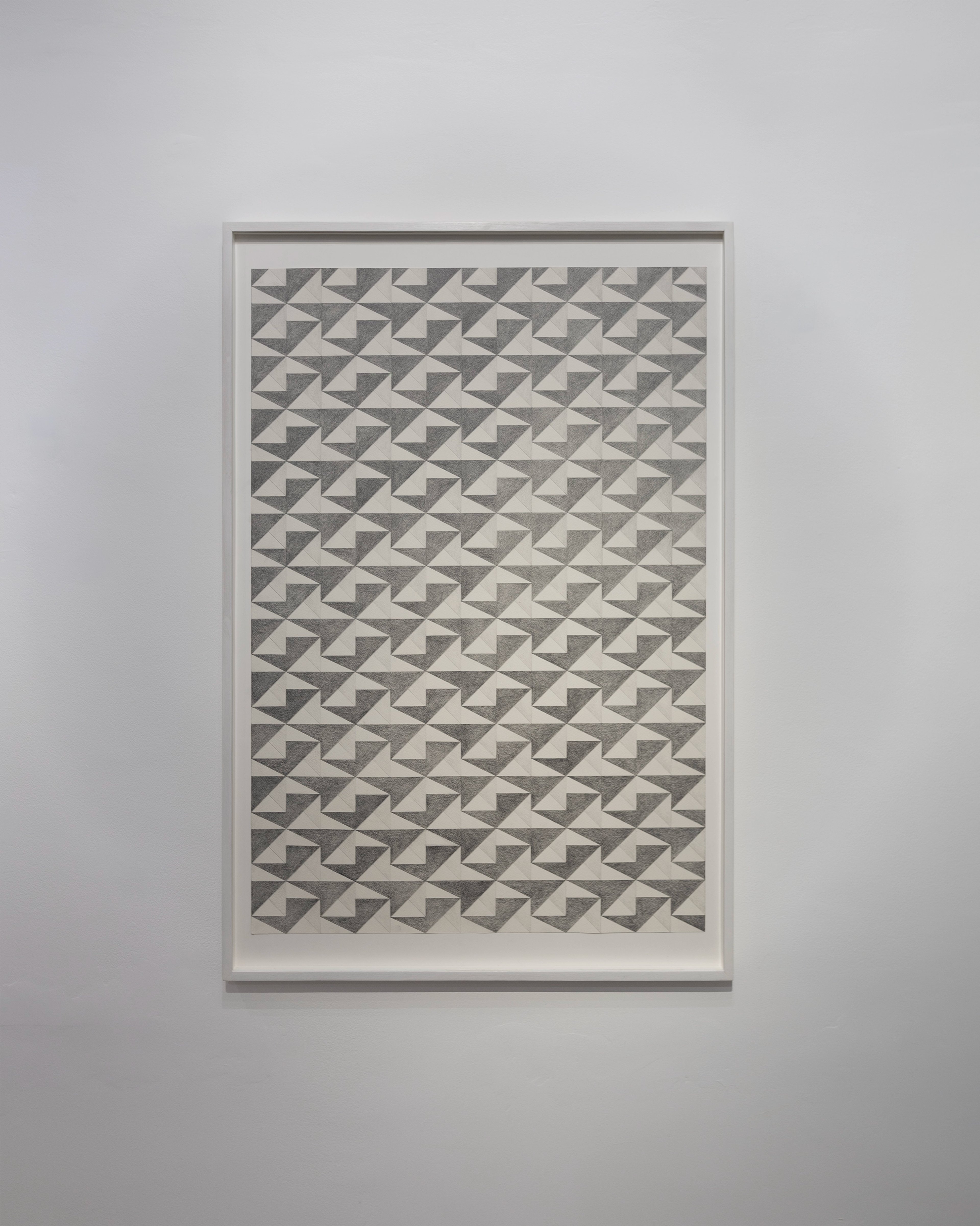 Framed graphite drawing on paper featuring a repeating geometric pattern of interlocking grey and cream triangles arranged in diagonal rows across the compos…