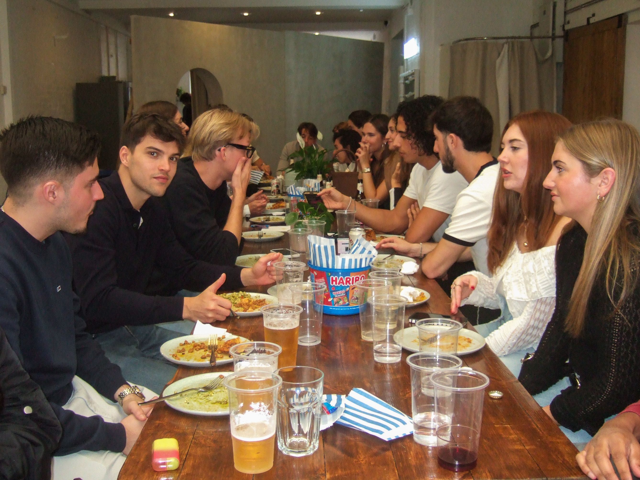 Guests sharing food and conversation during the JETLOST Sunday Family Reunion dinner at Brixton Warehouse, celebrating community and connection among young creatives.