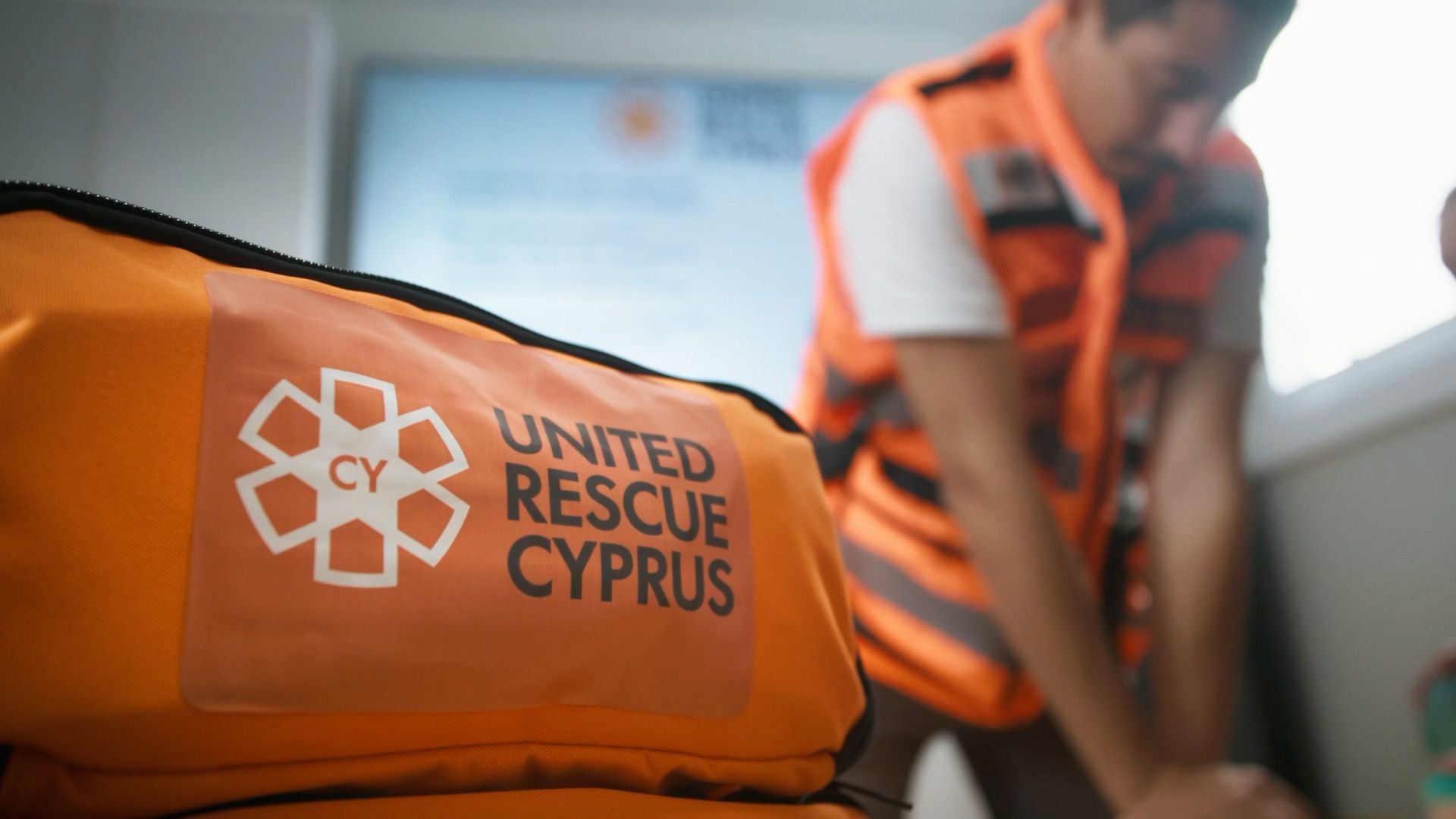 United Rescue Cyprus emergency medical kit beside a volunteer practising CPR.