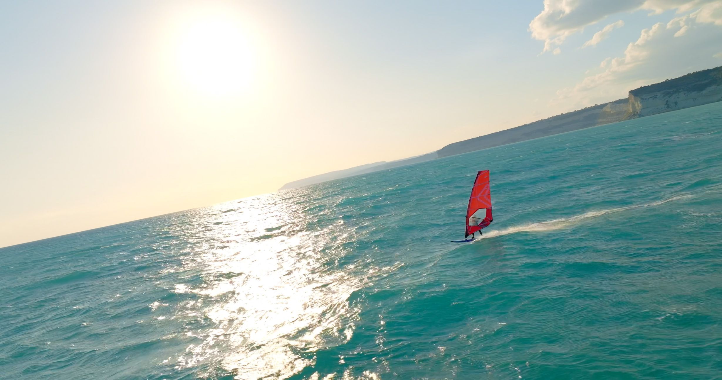 Windsurfer crossing the Mediterranean Sea in late afternoon light