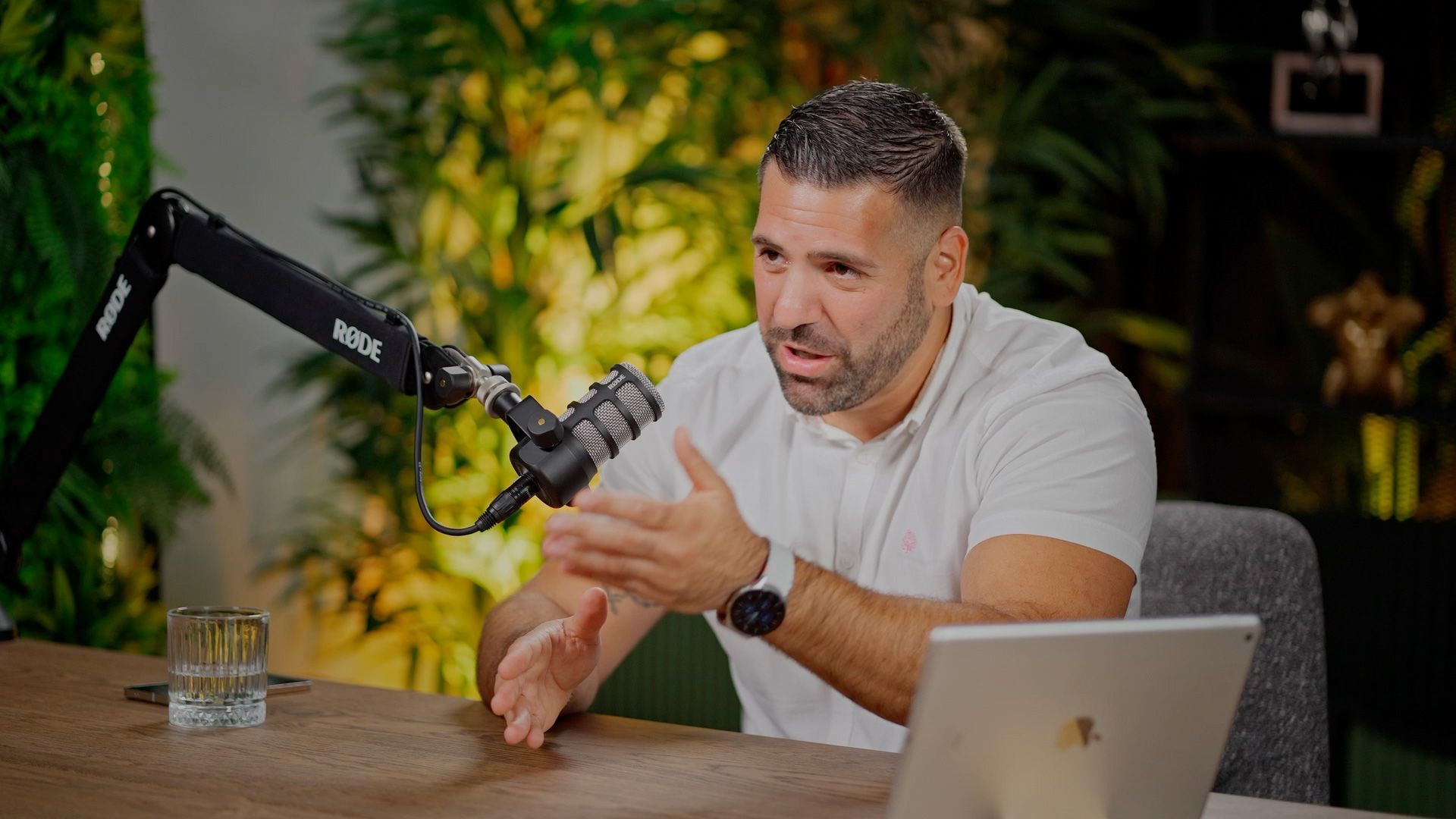 Podcast host speaking into a studio microphone during The Man Behind the Company.