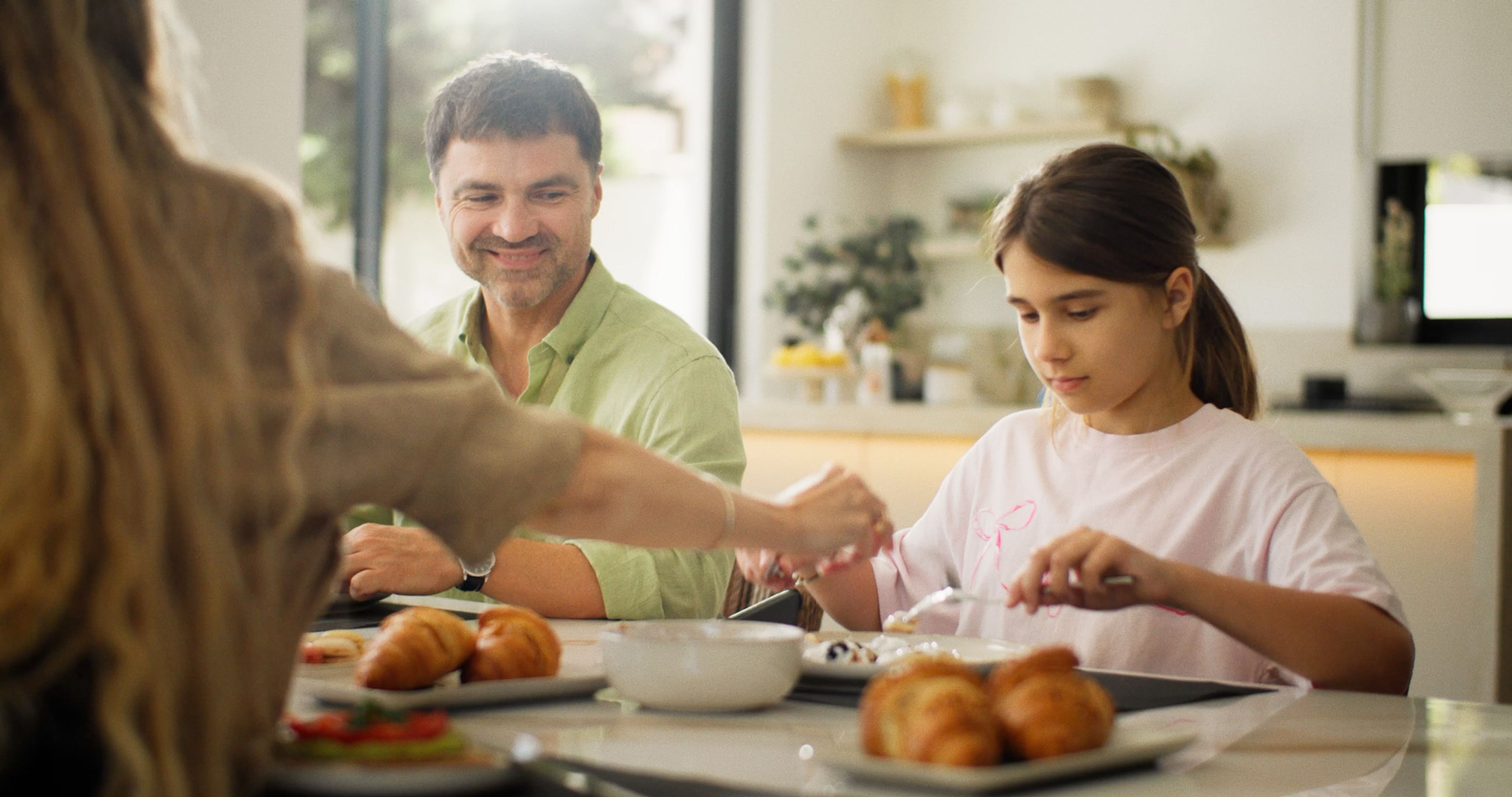 A family having breakfast together in a bright modern kitchen.