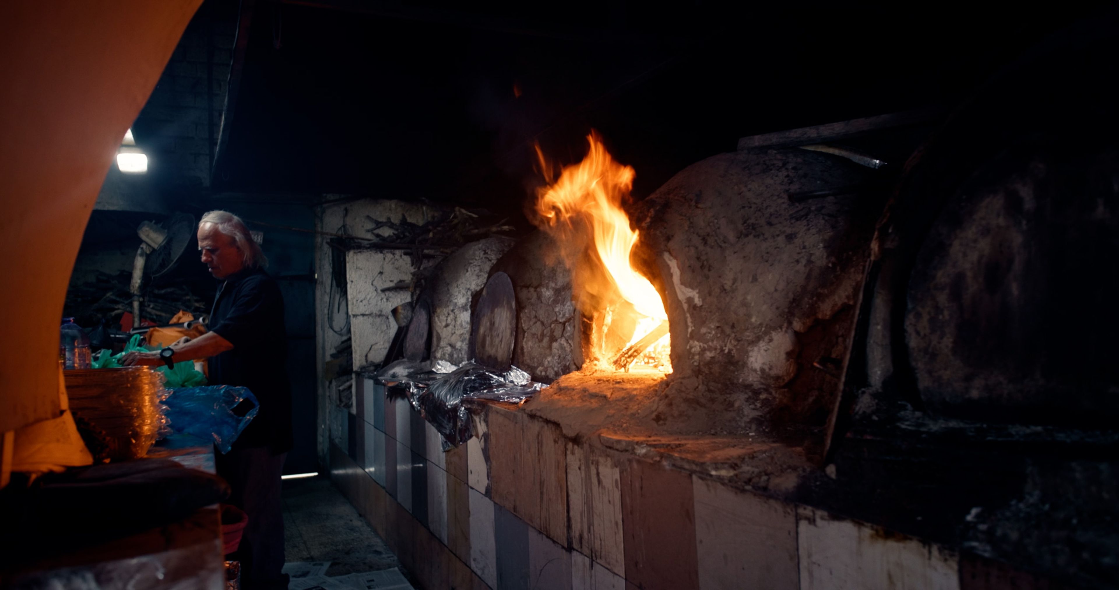 A traditional stone oven burning inside a local food workshop in Cyprus.