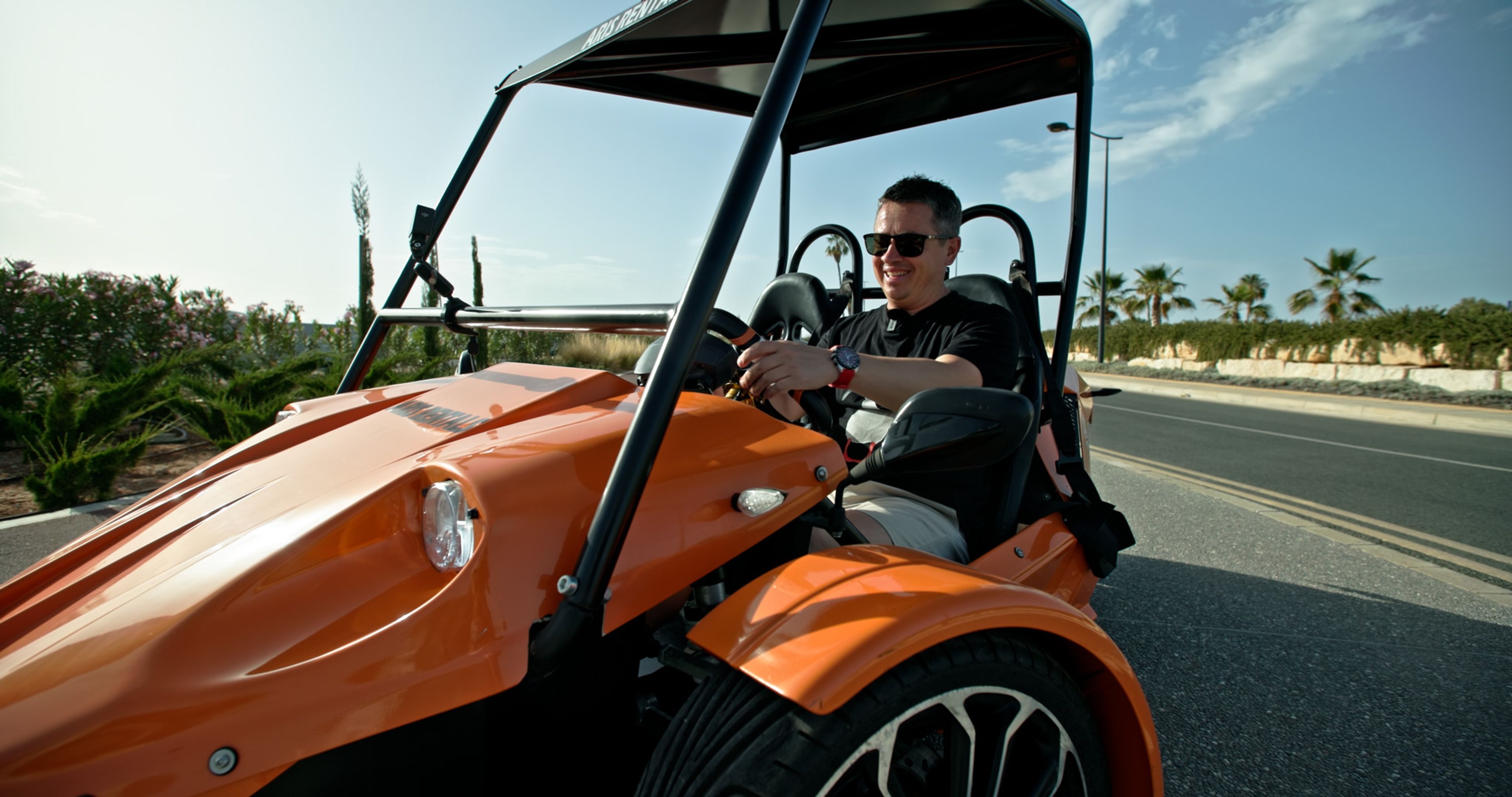 Andrey Iavita driving an orange buggy during a Discover Cyprus shoot.