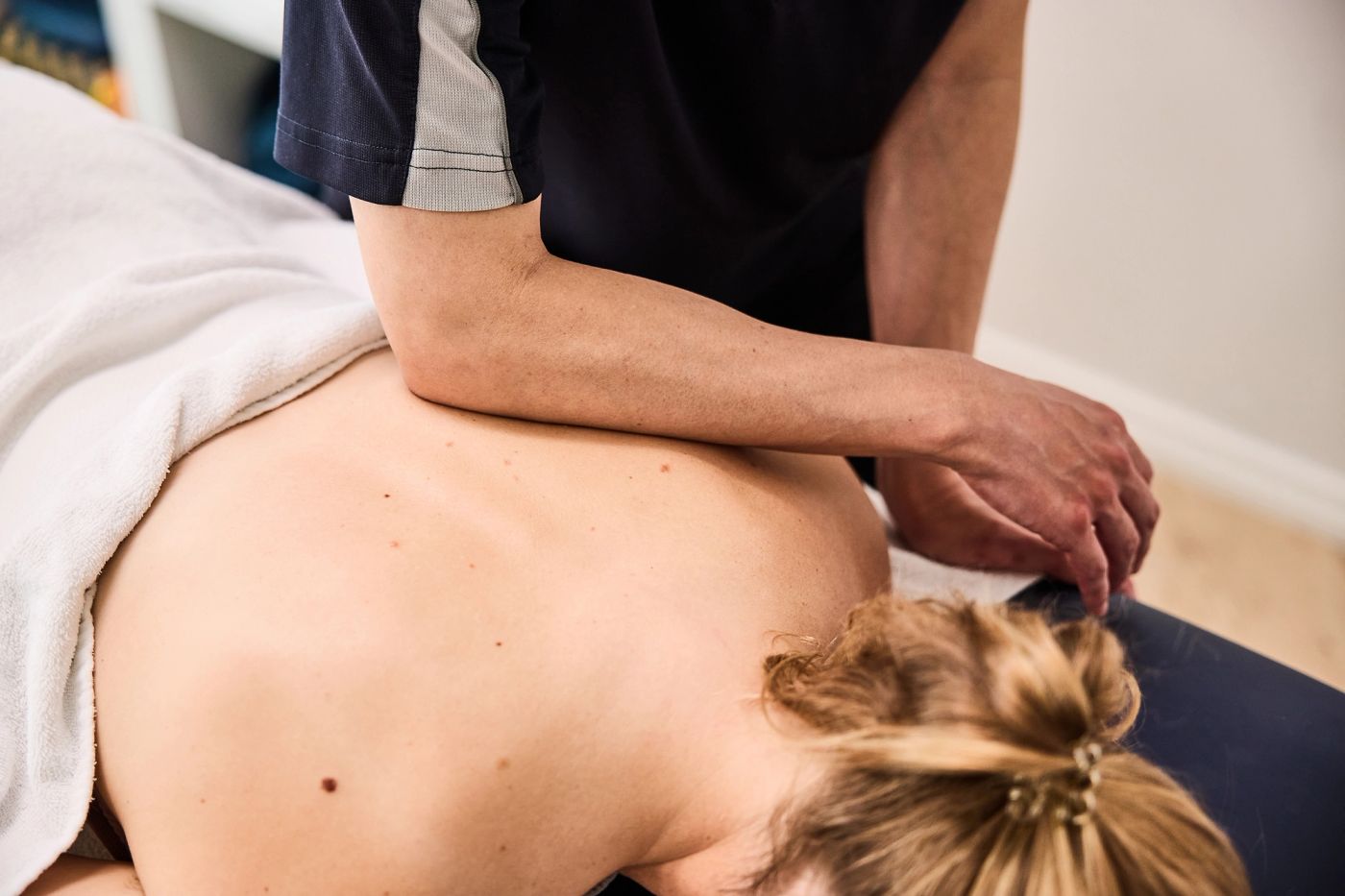 Physiotherapist massaging a patient’s upper back during treatment
