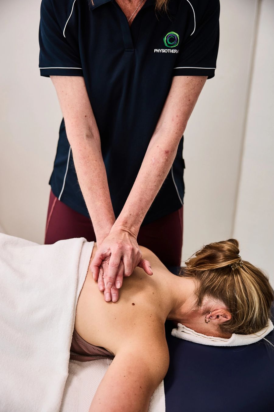 Physiotherapist massaging a patient’s upper back during treatment