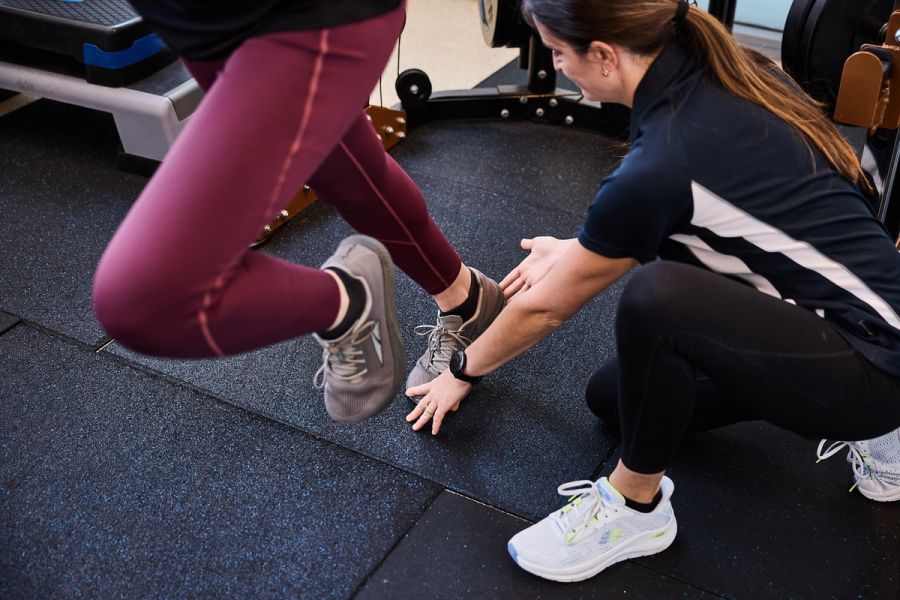 Physiotherapist coaching a client through a lunge during exercise rehabilitation
