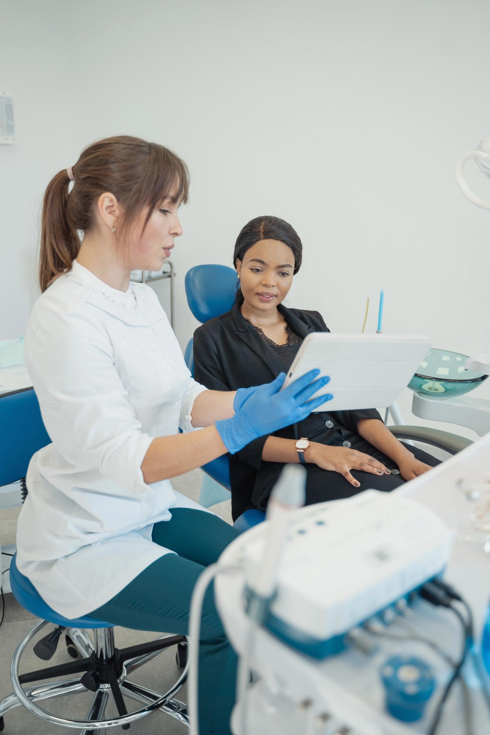 Dentist discussing information on a tablet with a patient