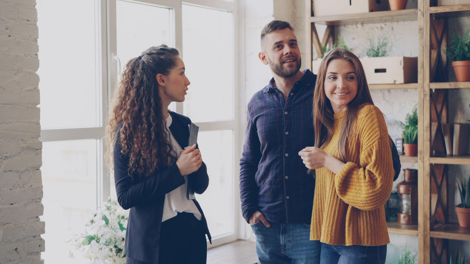 Real estate agent presenting a modern apartment to a couple