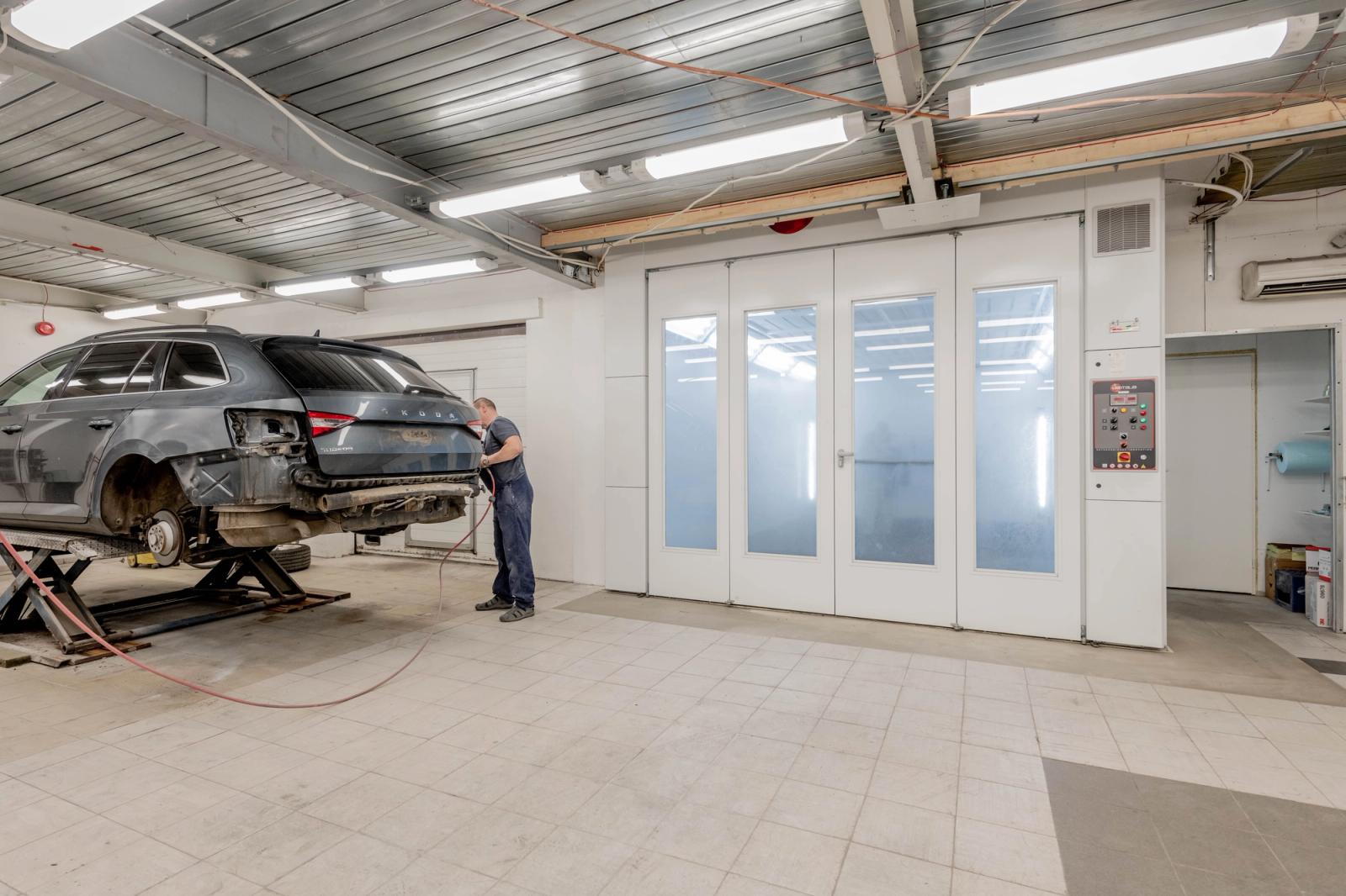 Mechanic working beside a vehicle in a modern auto repair workshop