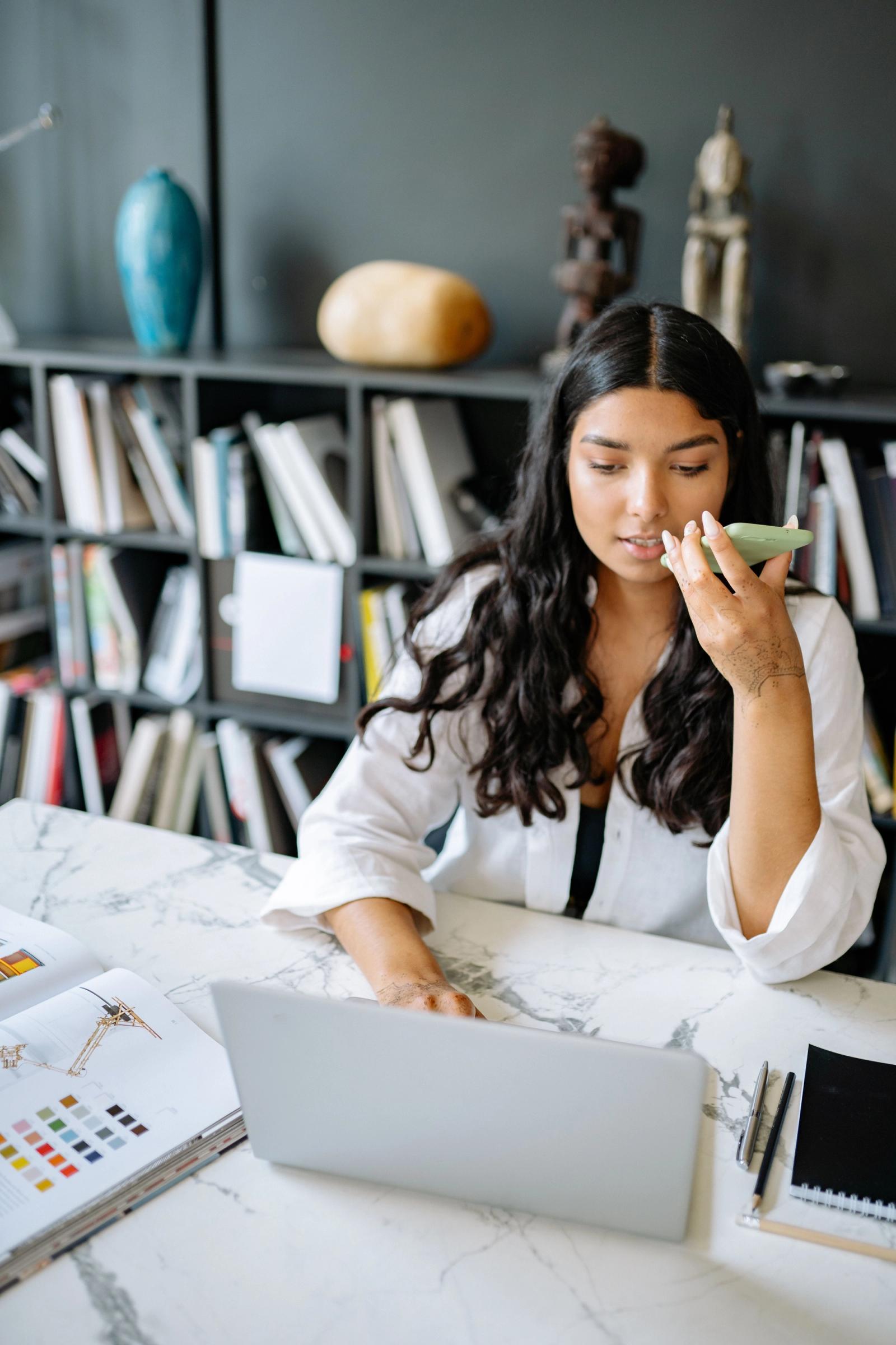 Office professional using a mobile phone while working on a laptop