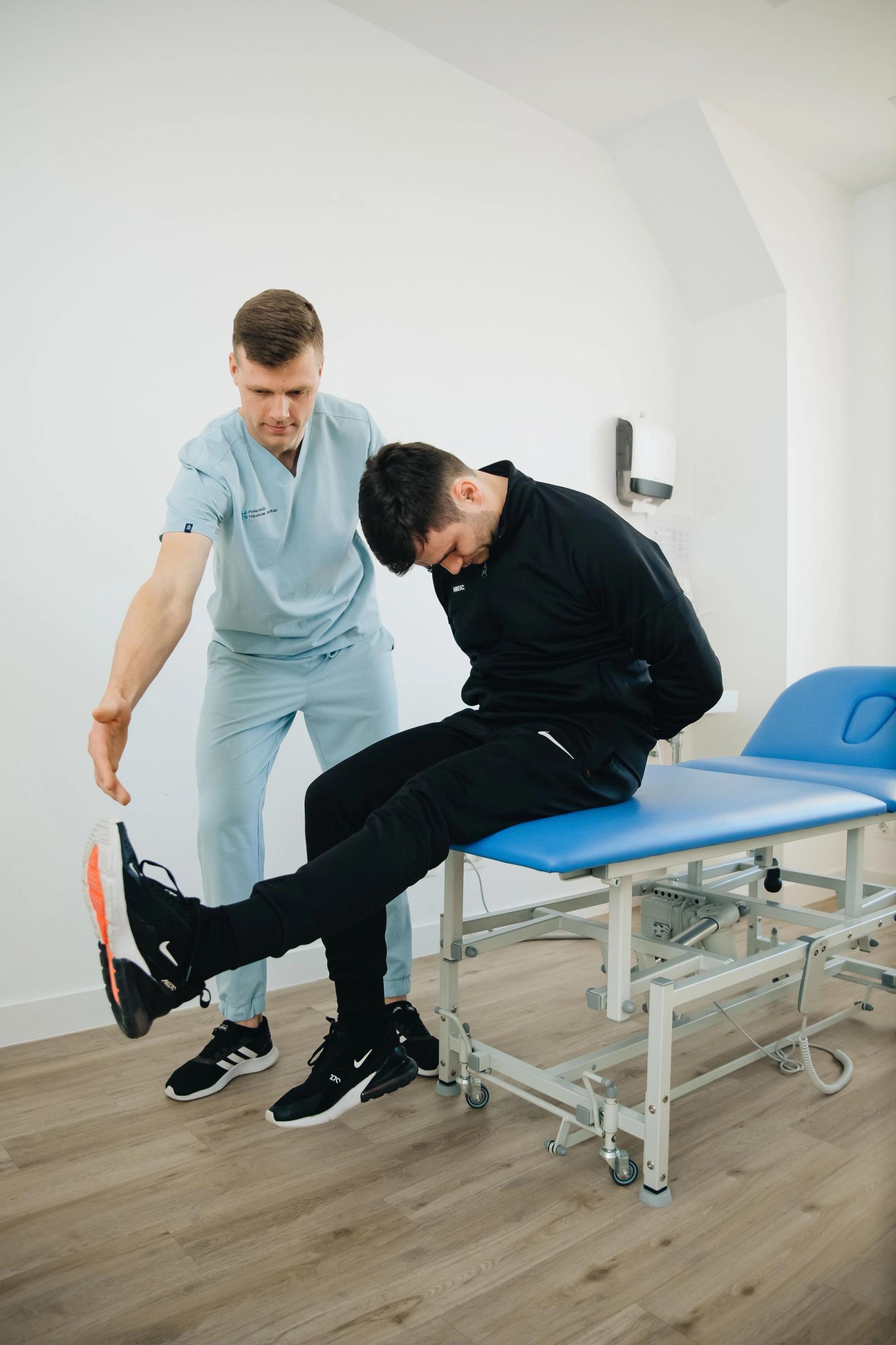 Physiotherapist assisting a patient with rehabilitation exercises on a treatment table