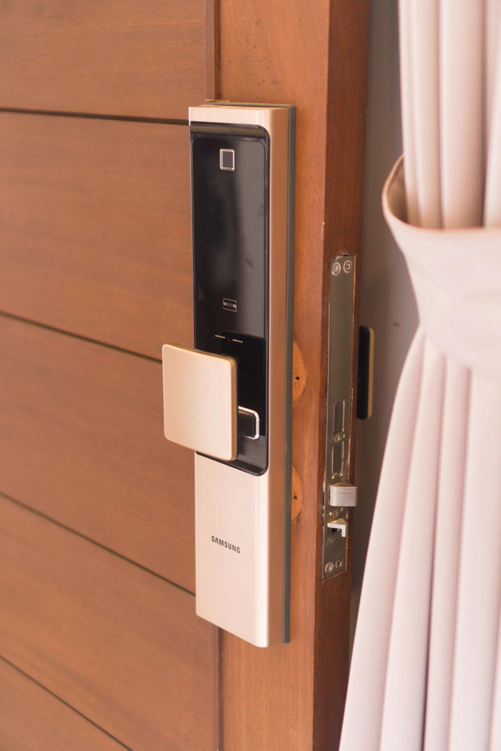 Close-up of a digital smart lock and handle on a wooden residential door